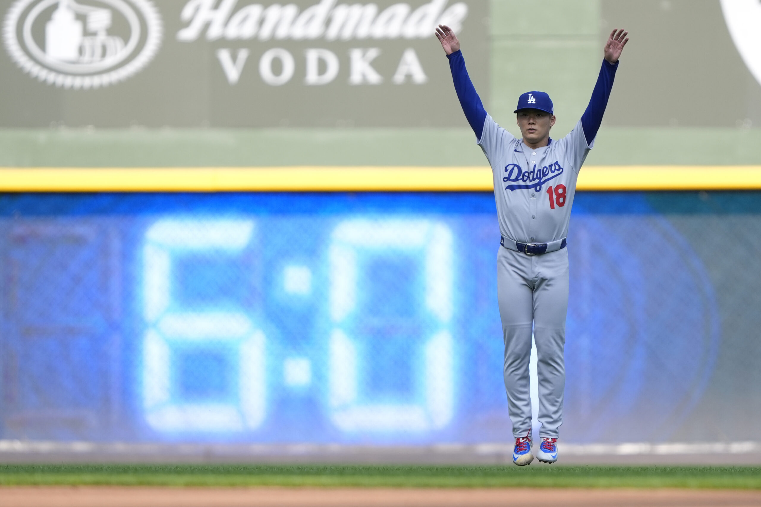 Dodgers starting pitcher Yoshinobu Yamamoto warms up before a baseball...