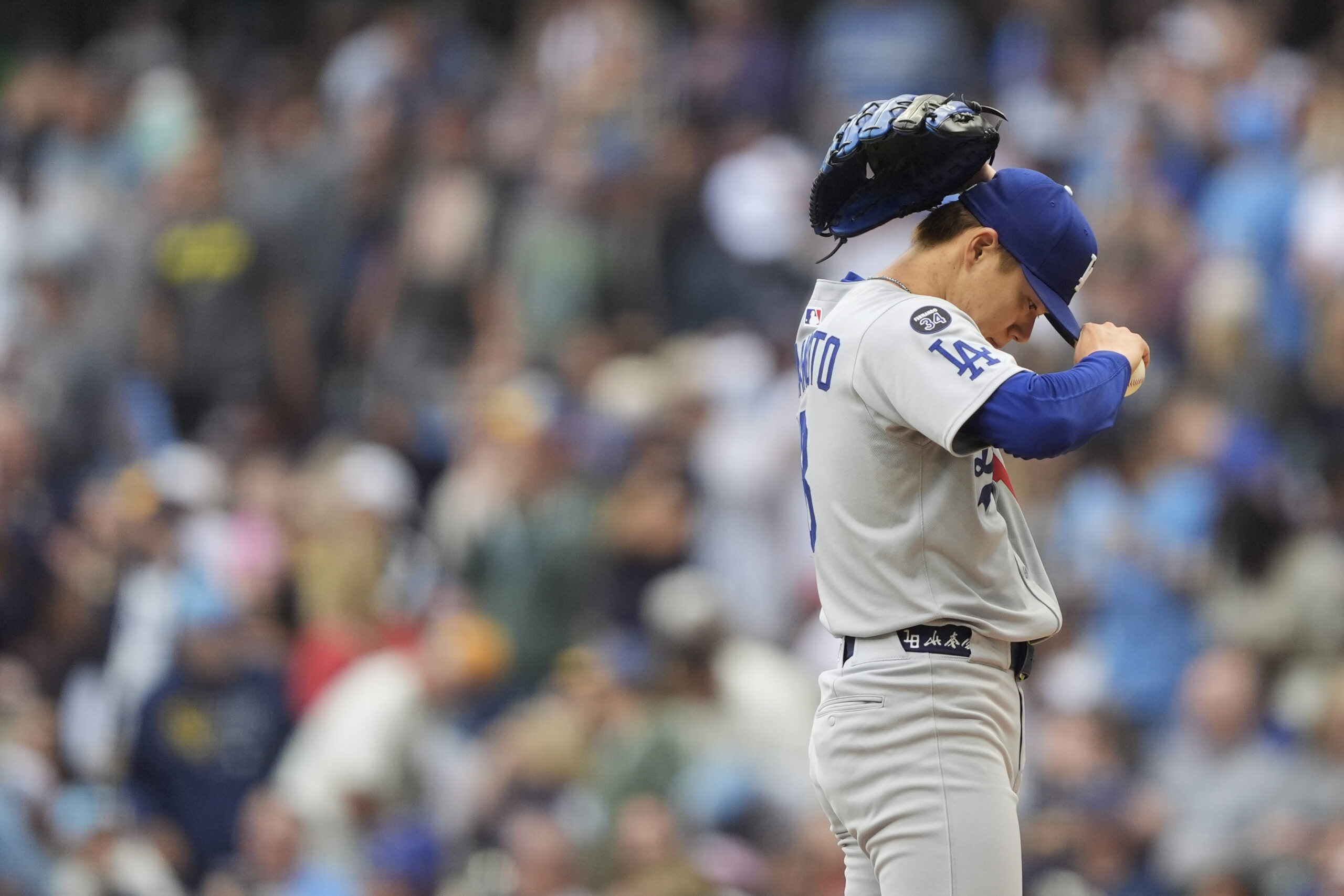 Dodgers starting pitcher Yoshinobu Yamamoto adjusts his cap during the...