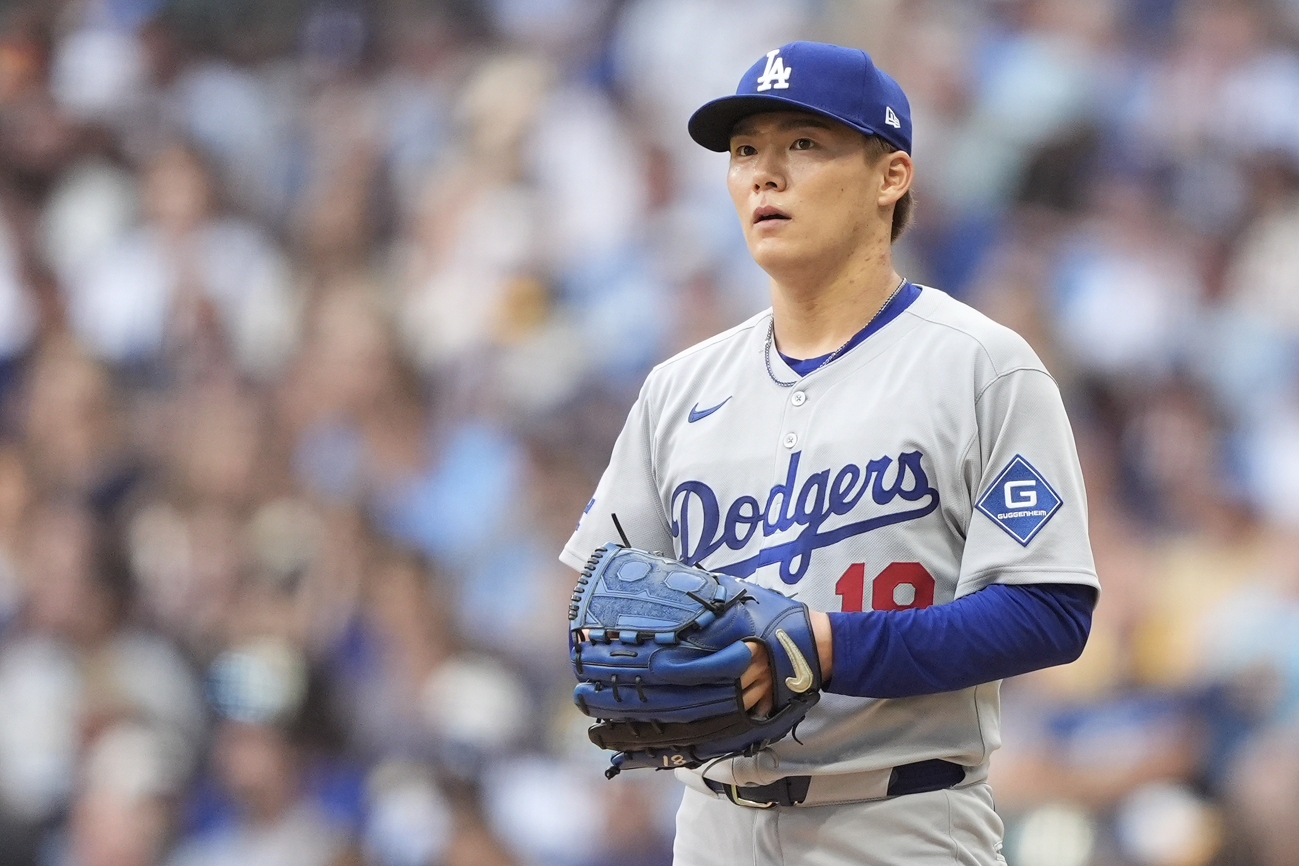Dodgers starting pitcher Yoshinobu Yamamoto looks on during the first...