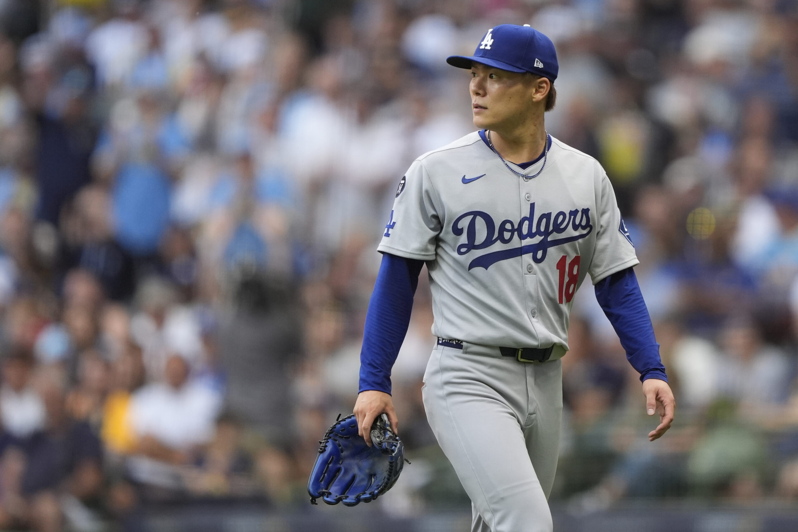 Dodgers starting pitcher Yoshinobu Yamamoto looks on after being removed...
