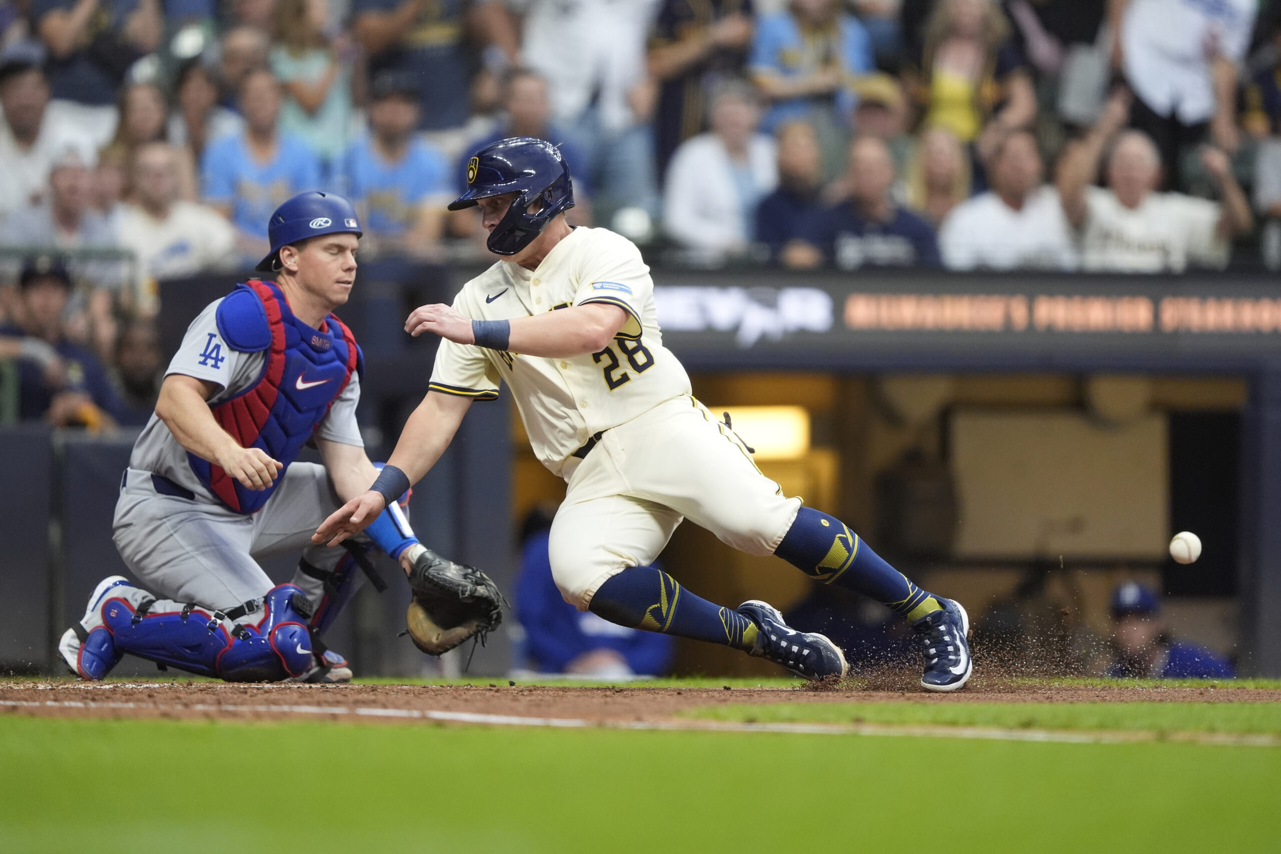 The Milwaukee Brewers’ Andrew Vaughn, right, scores at home past...