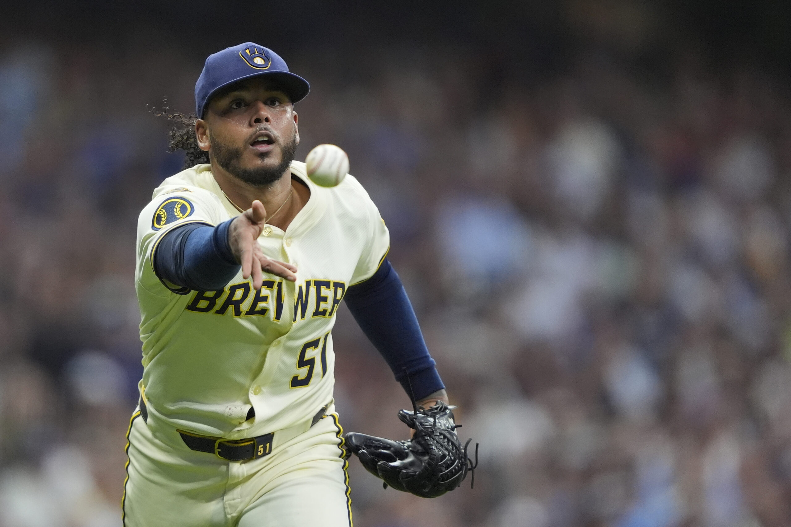 Milwaukee Brewers starting pitcher Freddy Peralta tosses the ball to...