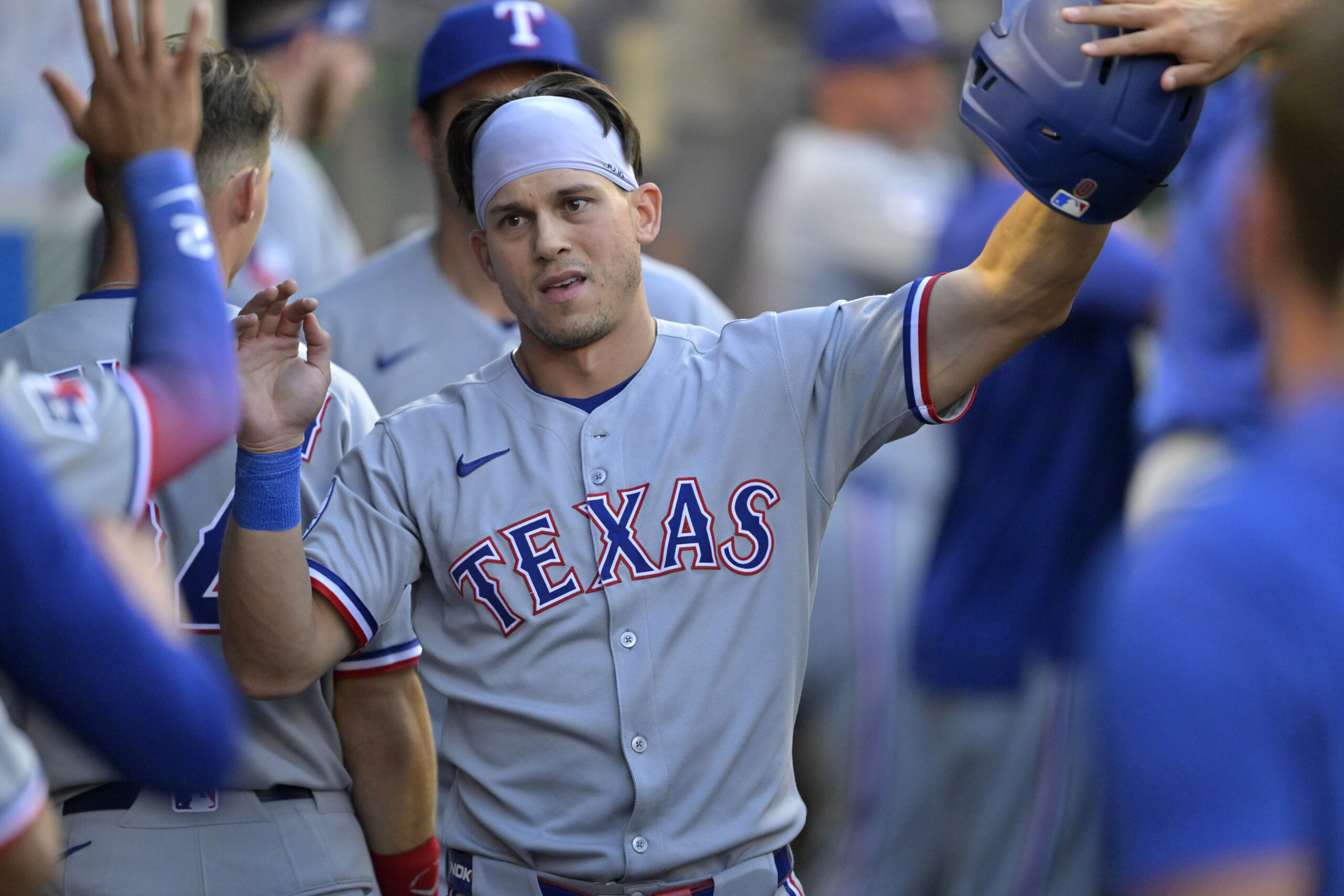 The Texas Rangers’ Sam Haggerty is greeted in the dugout...