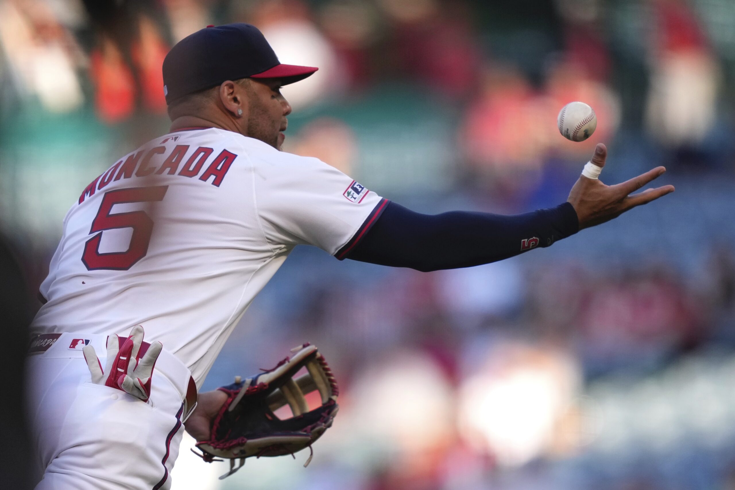 Angels third baseman Yoán bobbles a ball hit by the...