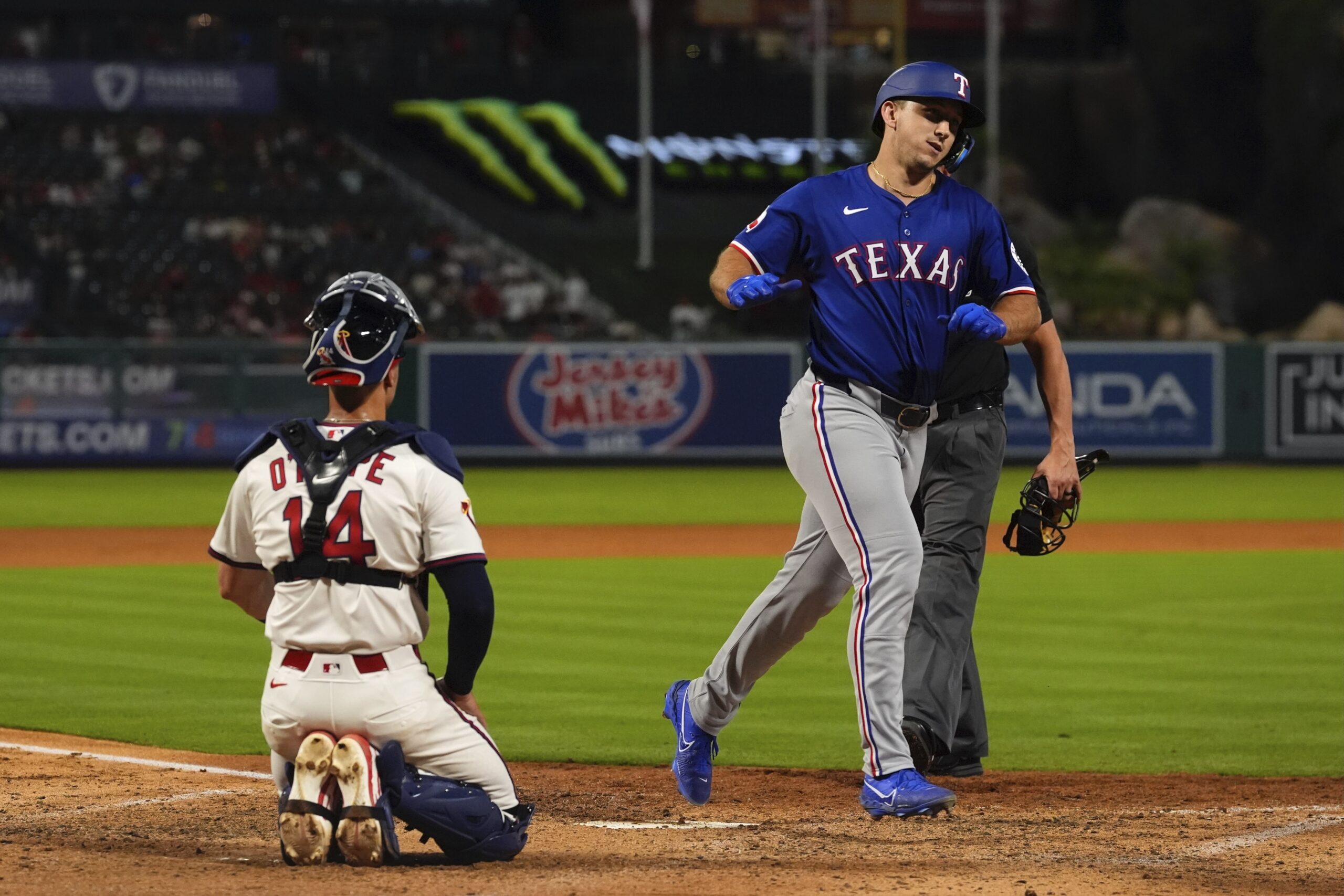 The Texas Rangers’ Wyatt Langford, right, crosses home plate after...