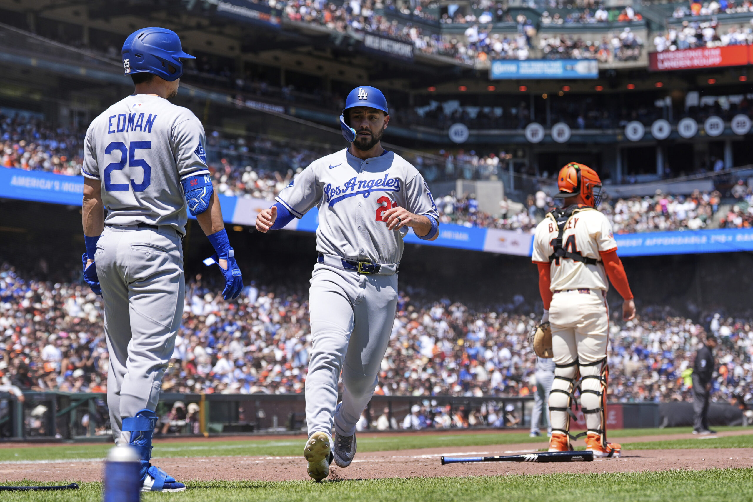 Los Angeles Dodgers’ Michael Conforto, center, scores against the San...