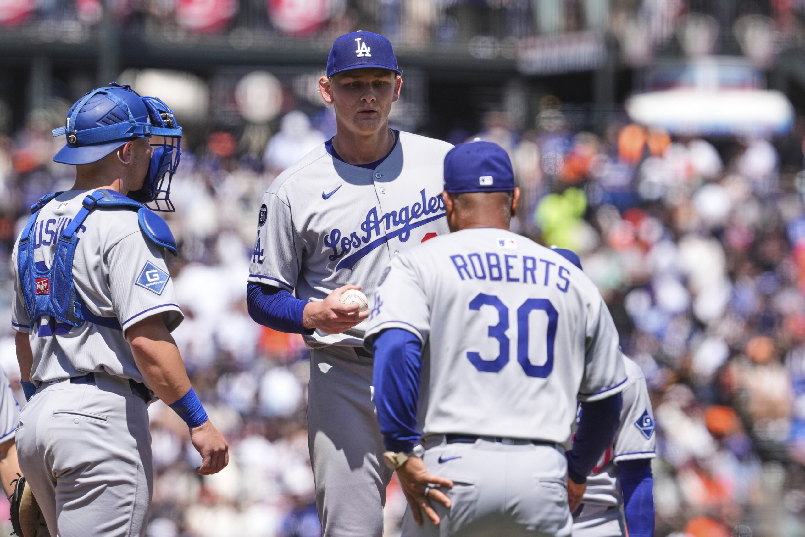 Los Angeles Dodgers pitcher Emmet Sheehan, center, hands the ball...