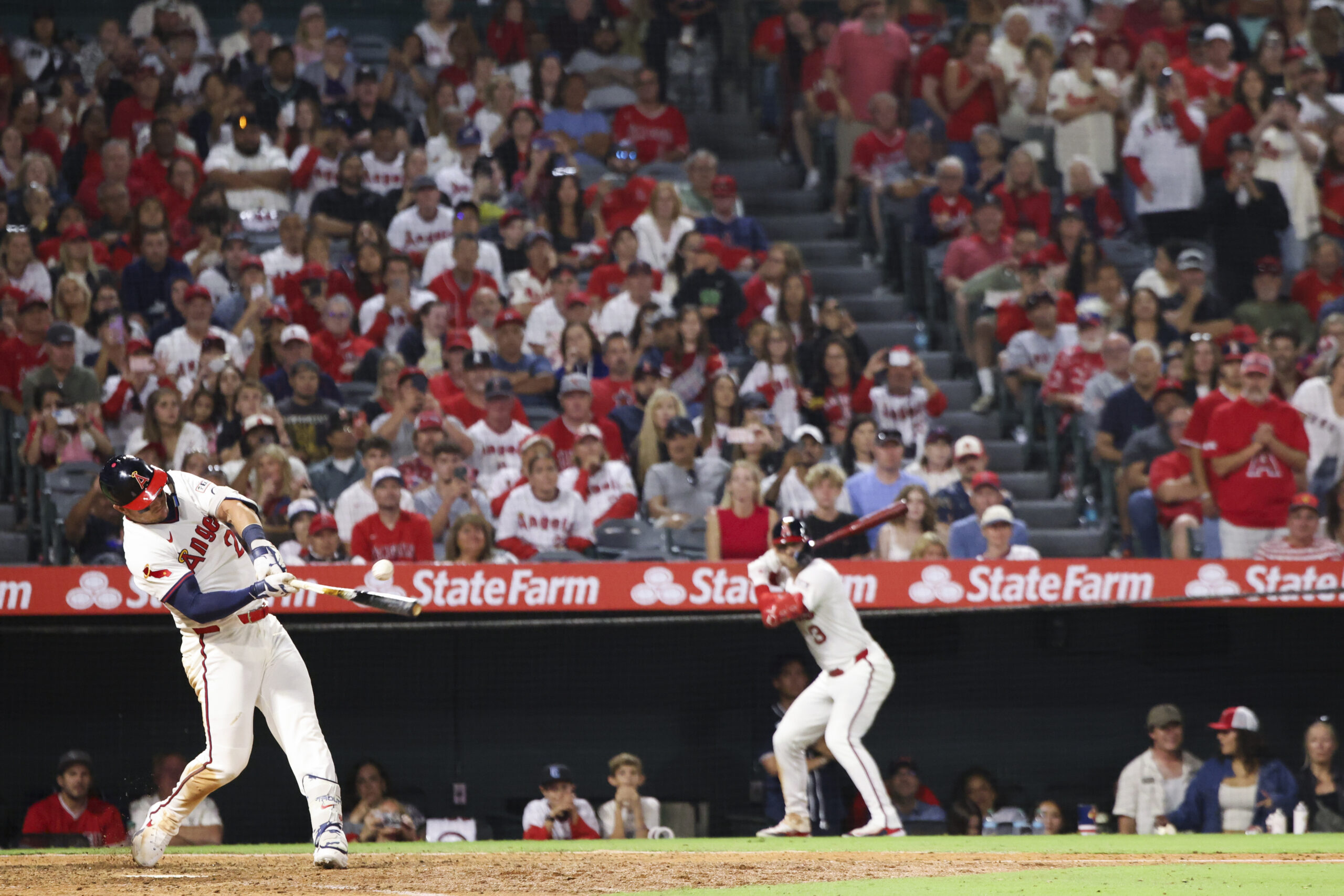 Angels’ Mike Trout, left, hits an RBI single during the...