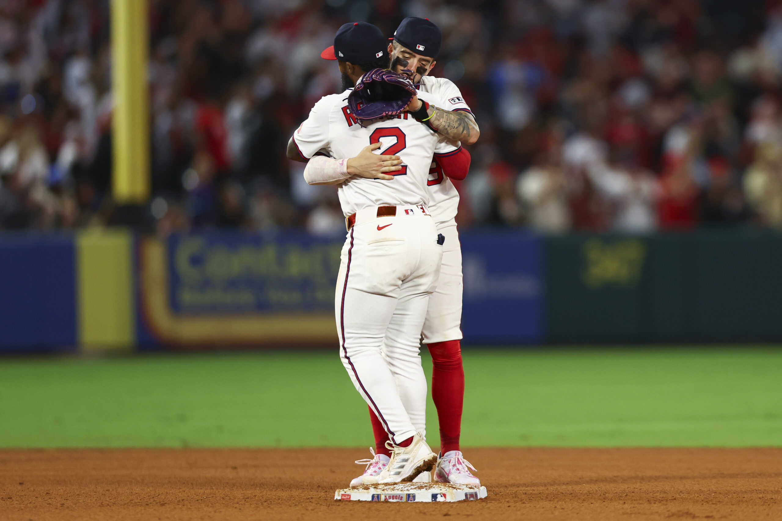 Angels second baseman Luis Rengifo (2) and shortstop Zach Neto,embrace...