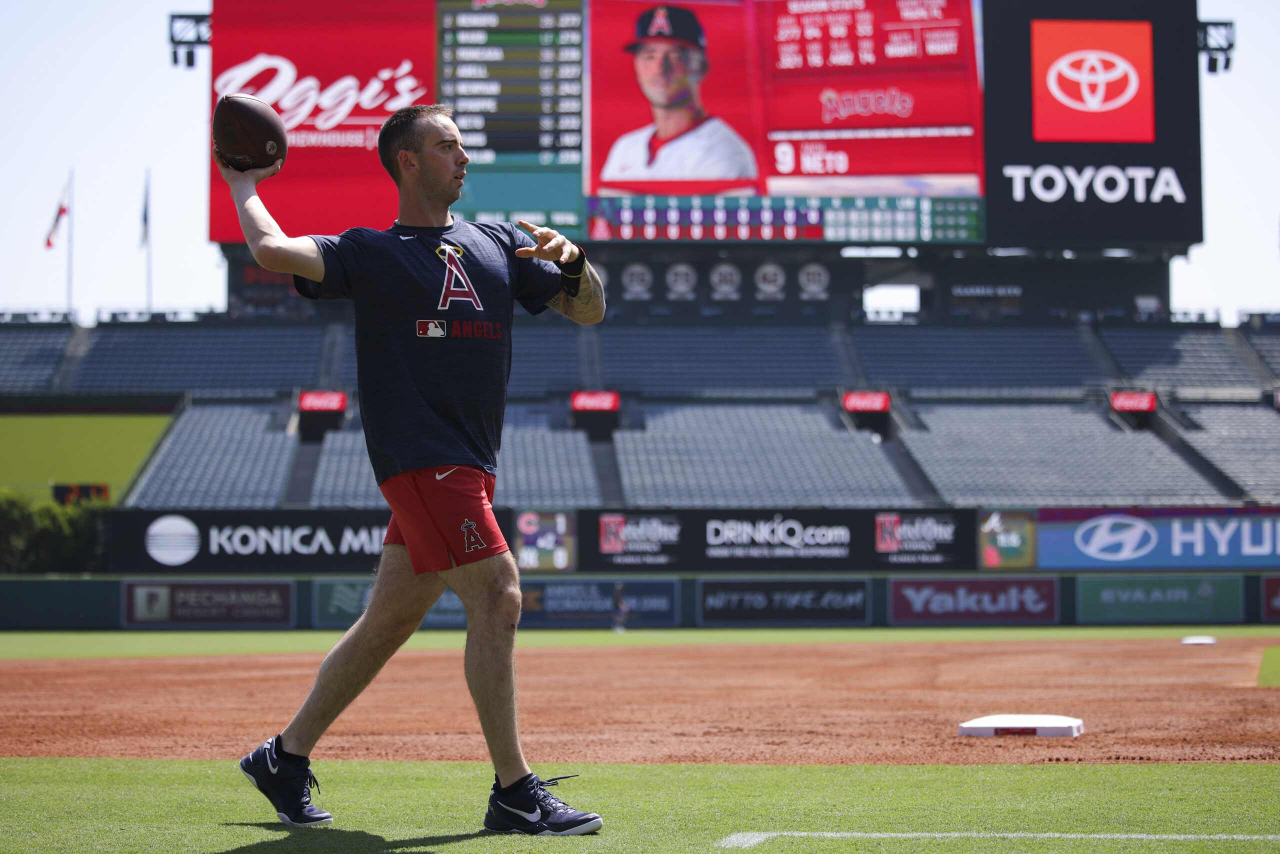 Los Angeles Angels’ Zach Neto warms up with a football...