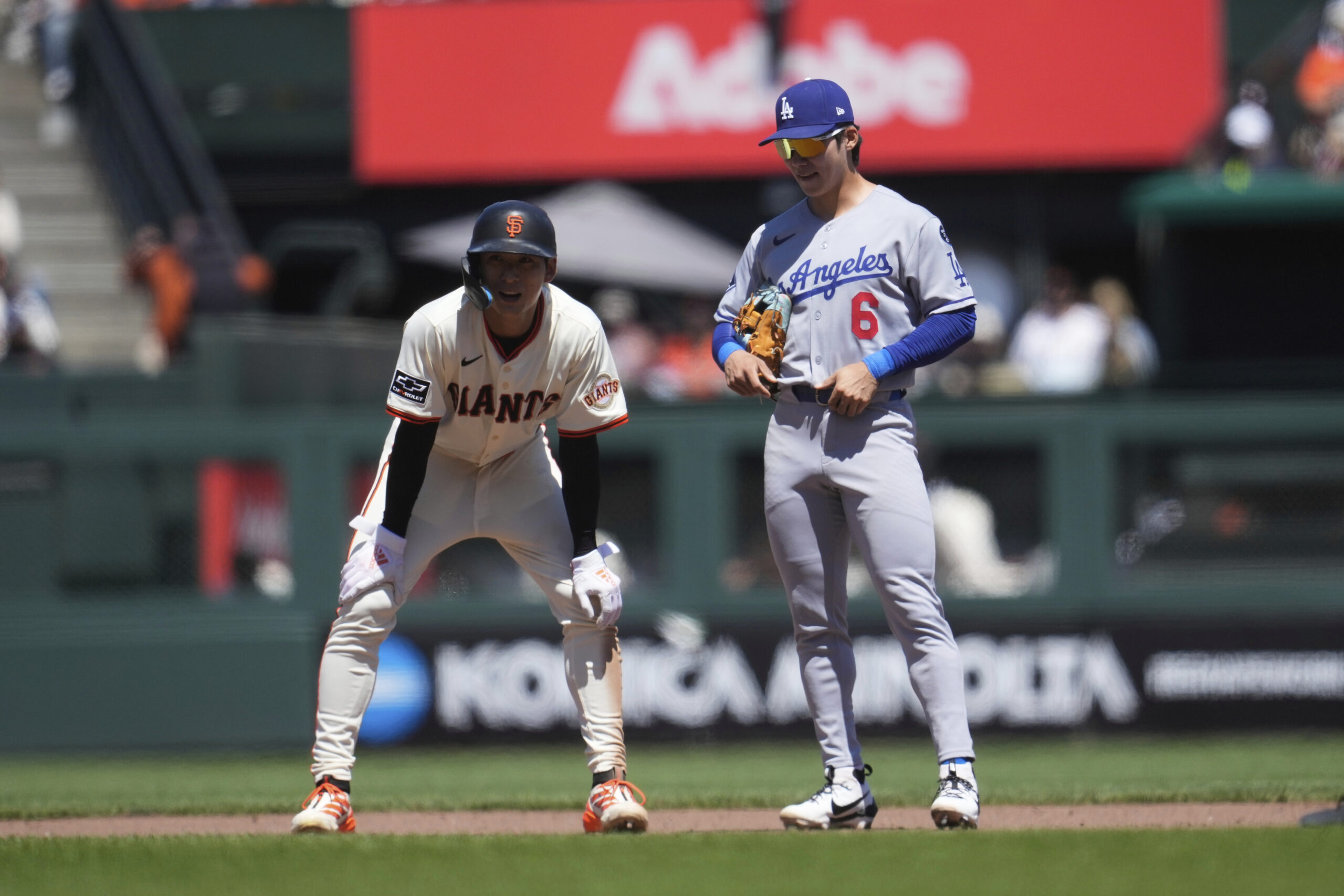 San Francisco Giants’ Jung Hoo Lee, left, talks with Dodgers...