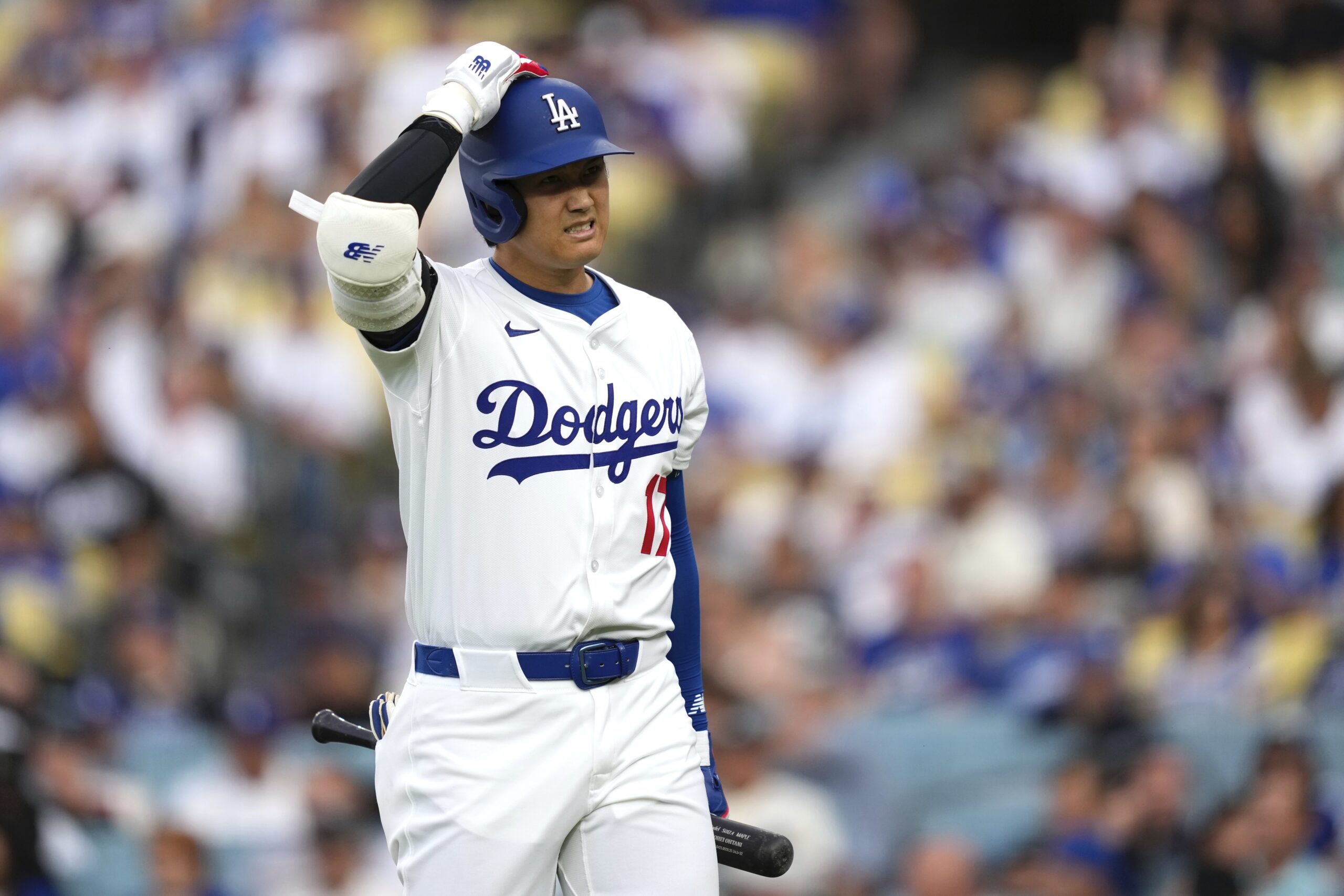 Dodgers star Shohei Ohtani walks back to the dugout after...