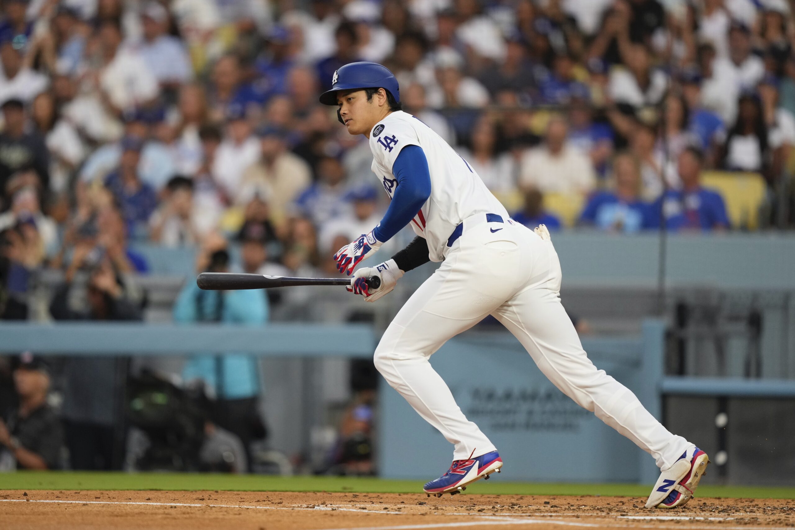 Dodgers star Shohei Ohtani runs to first as he grounds...