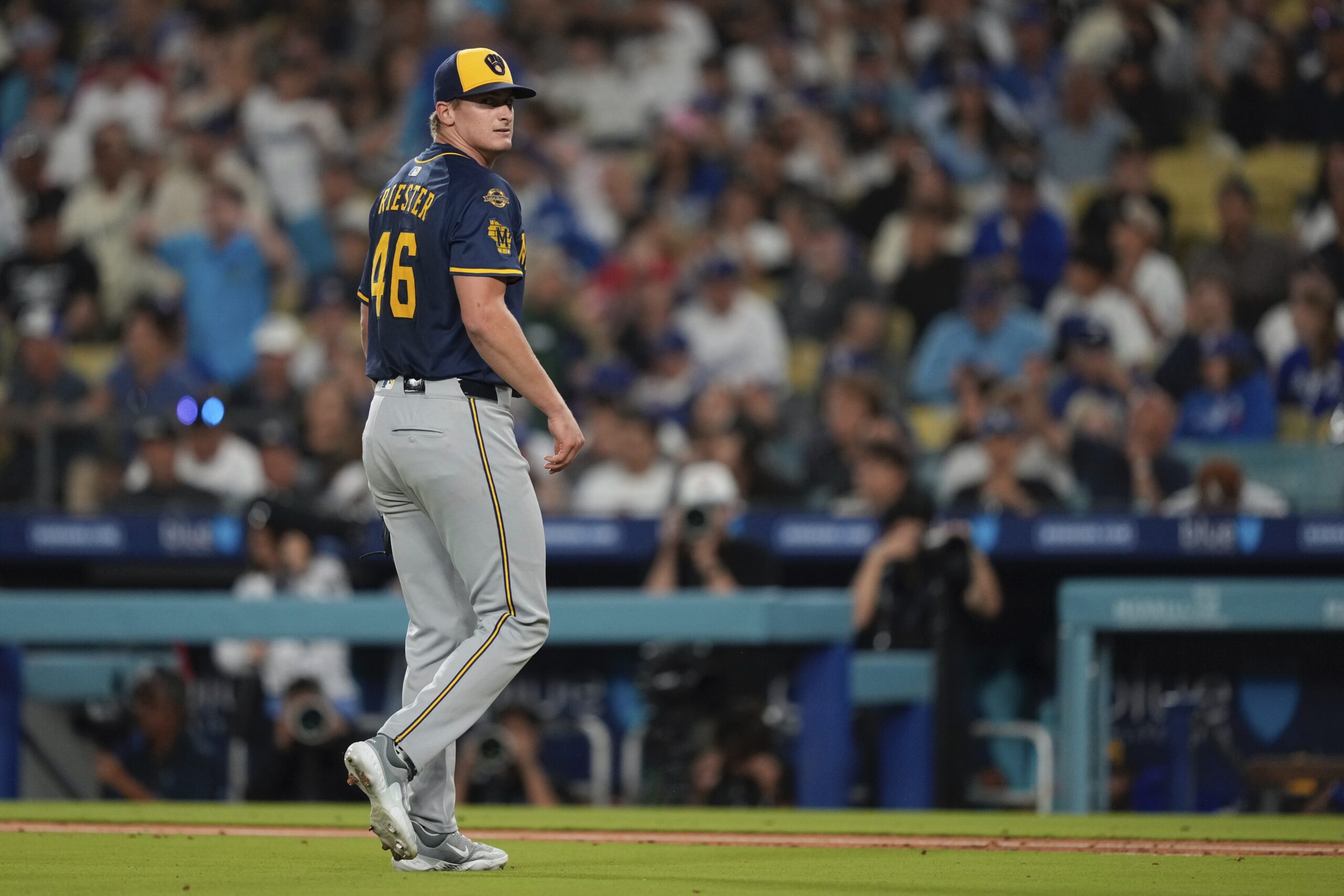 Milwaukee Brewers starting pitcher Quinn Priester walks to the dugout...