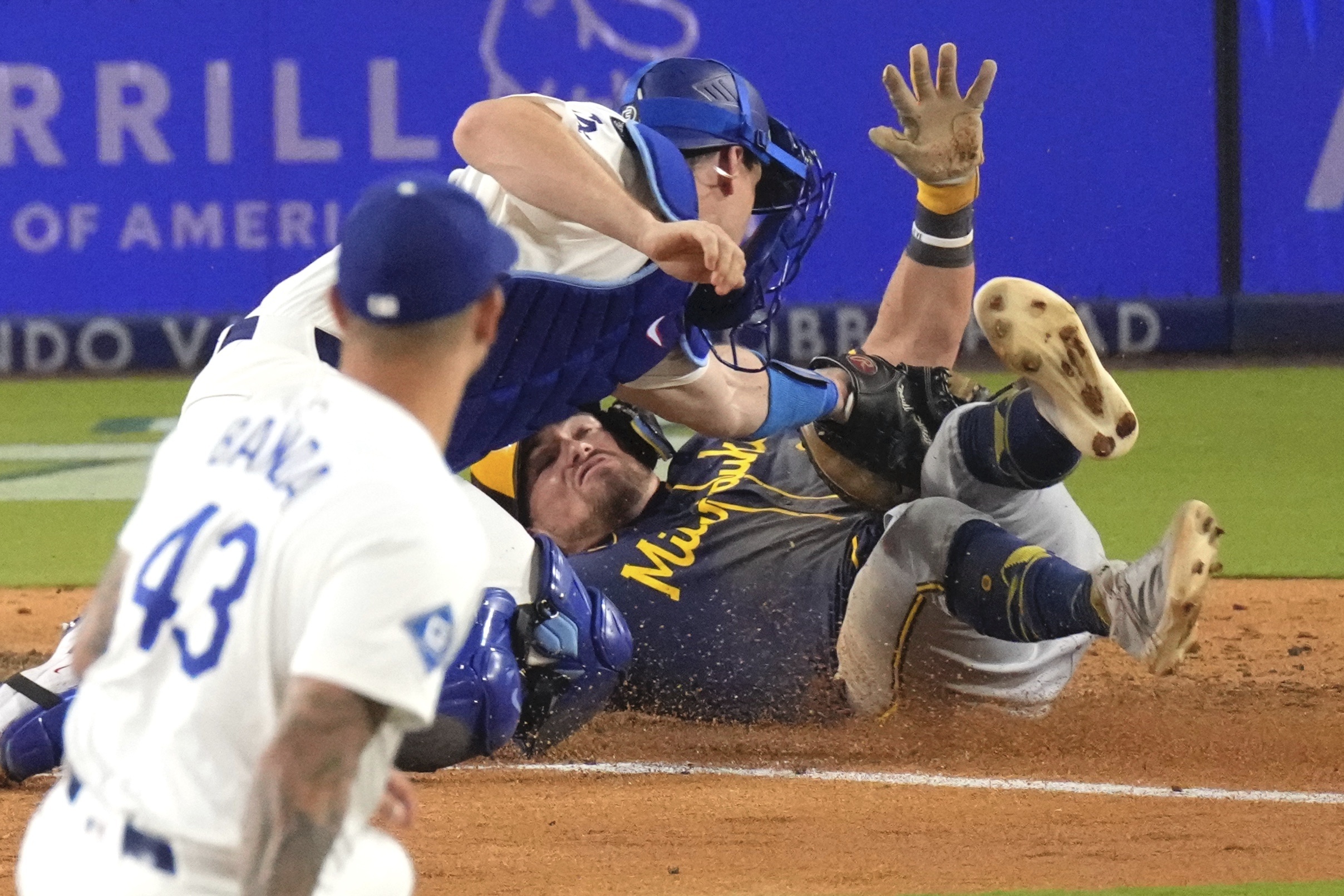 Dodgers catcher Will Smith, center, tags out the Milwaukee Brewers’...