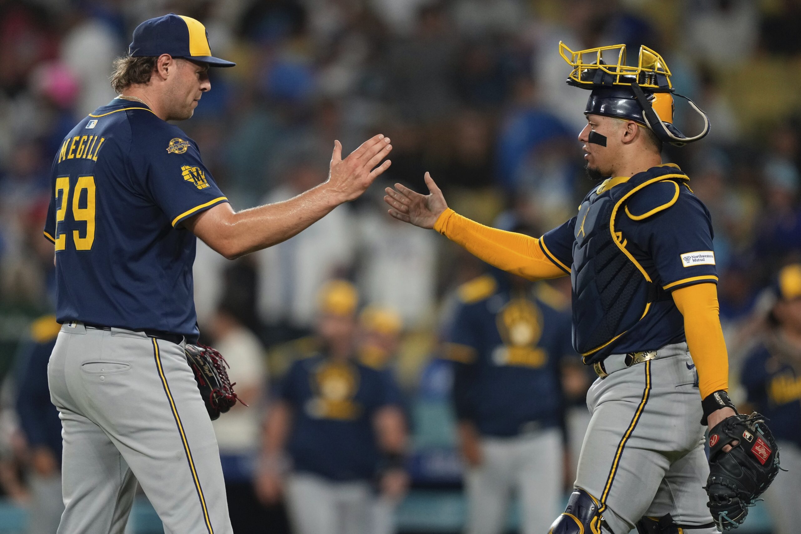 Milwaukee Brewers relief pitcher Trevor Megill, left and catcher William...