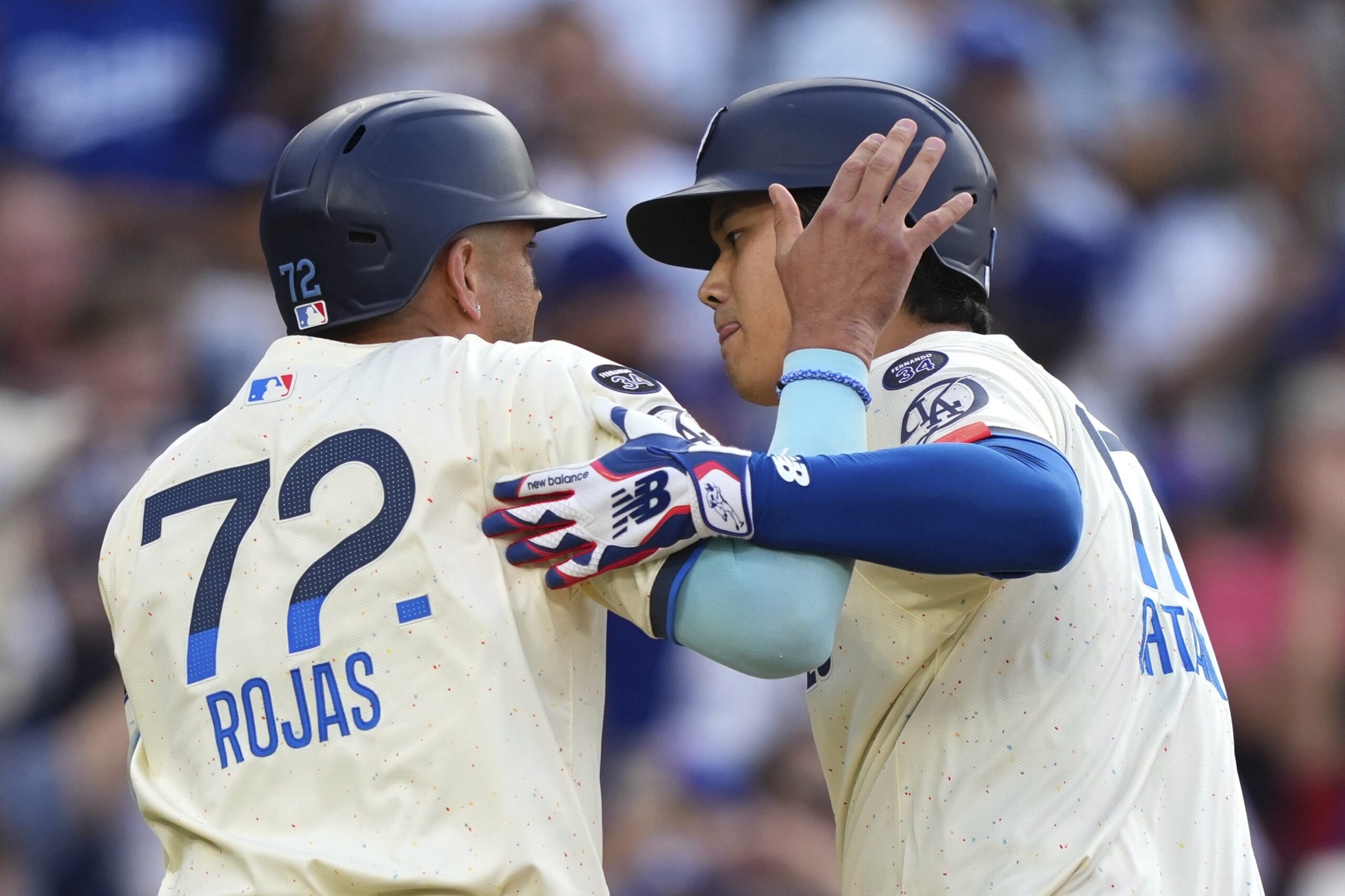 Dodgers’ Shohei Ohtani, right, is congratulated by Miguel Rojas after...