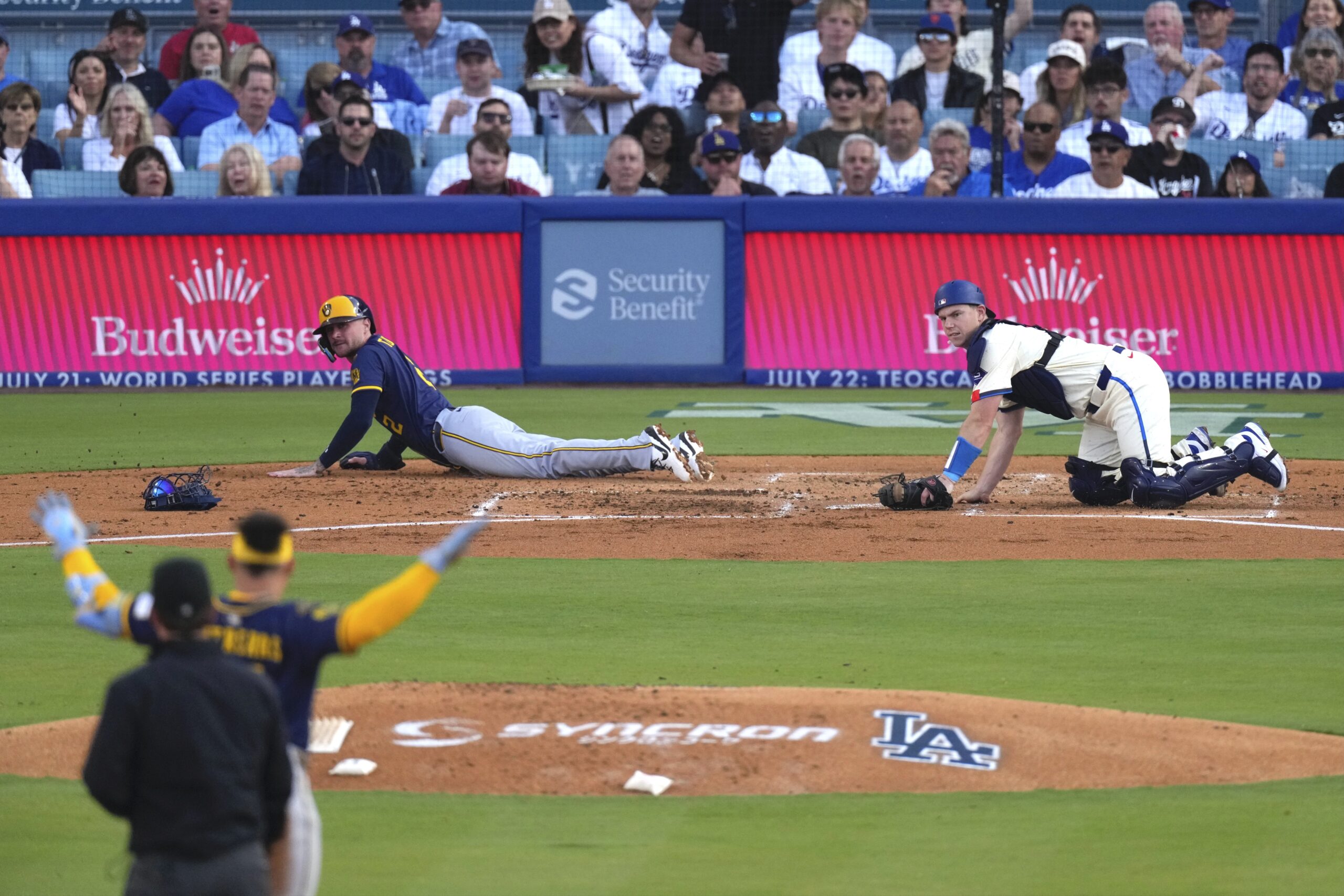 Milwaukee Brewers’ Brice Turang, center, looks up after scoring on...