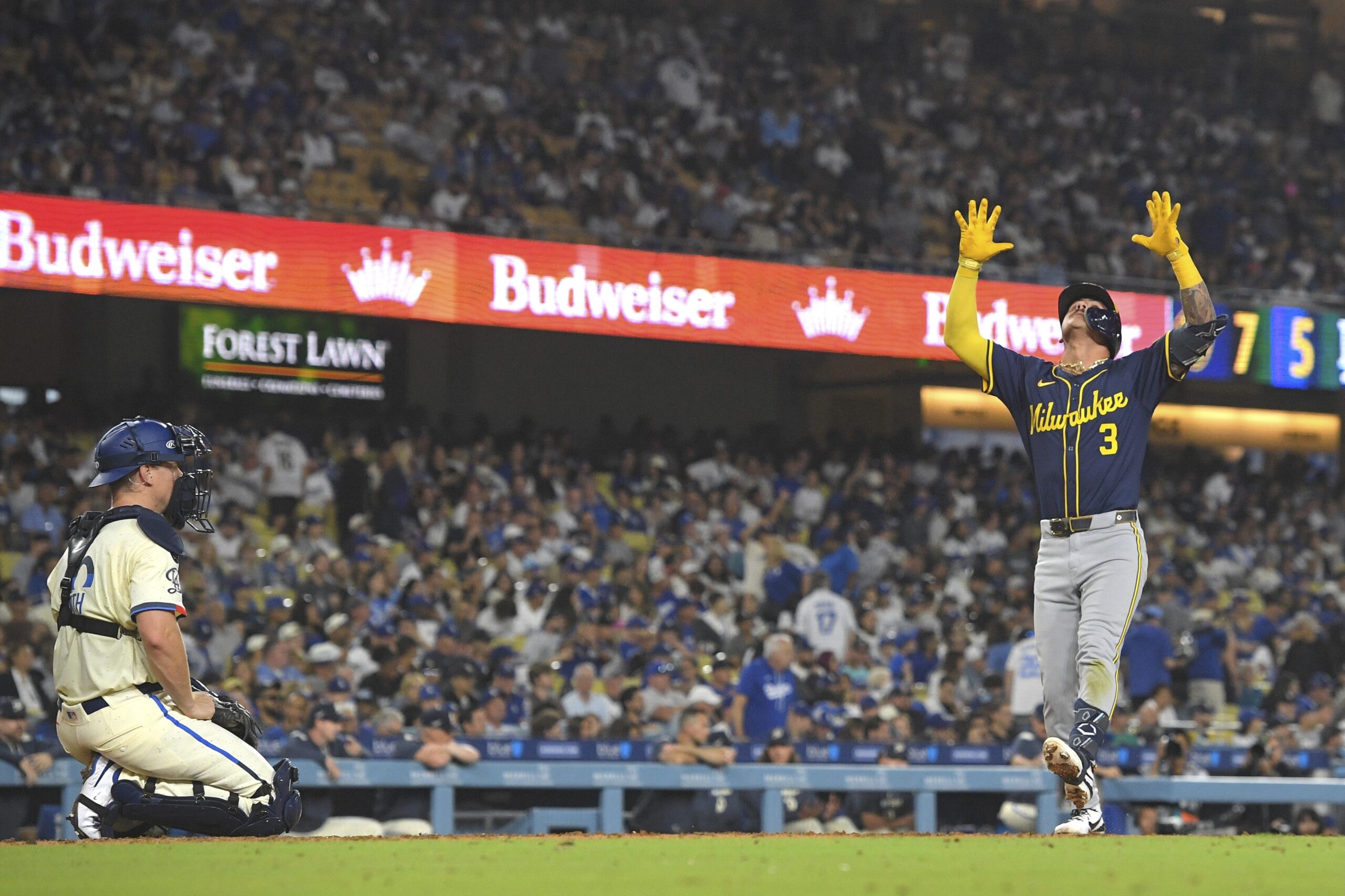 Milwaukee Brewers’ Joey Ortiz, right, gestures as he scores after...