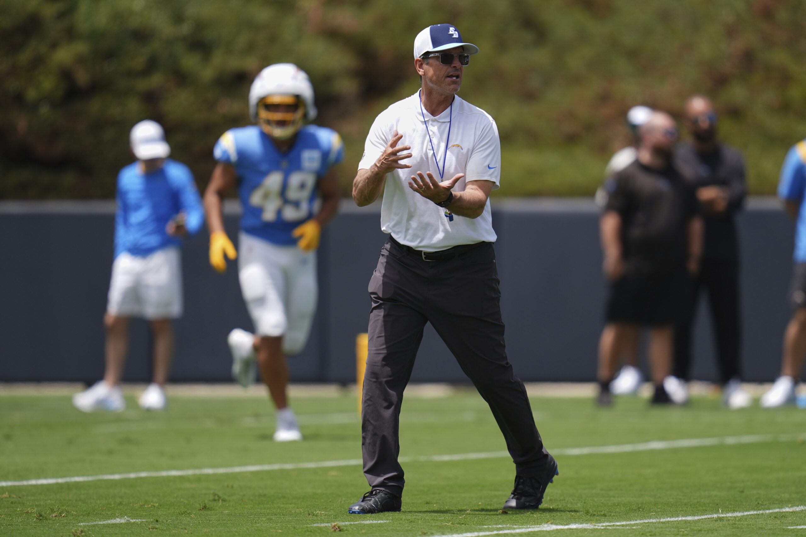 Chargers head coach Jim Harbaugh gestures as he works with...