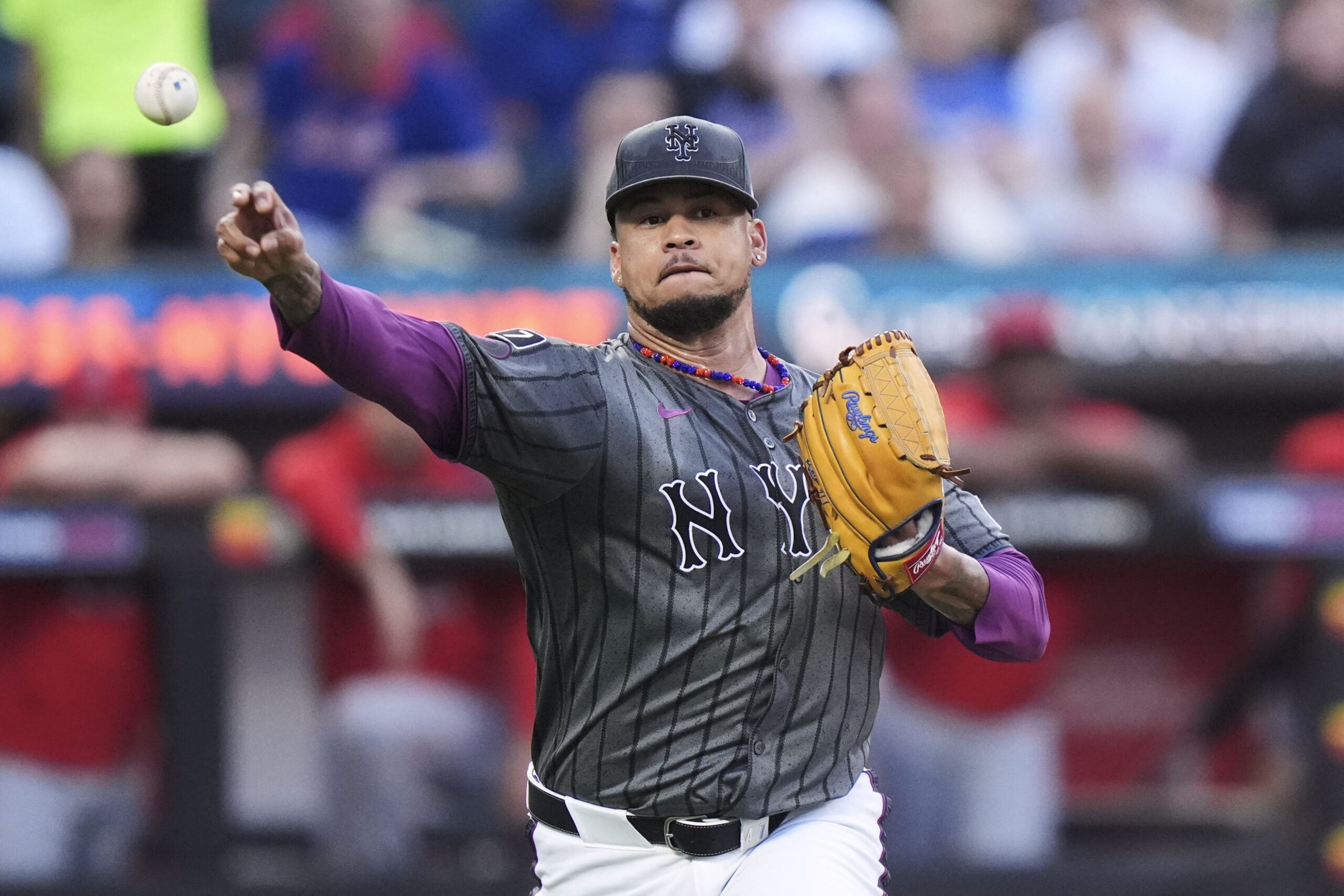 New York Mets starting pitcher Frankie Montas throws to first...