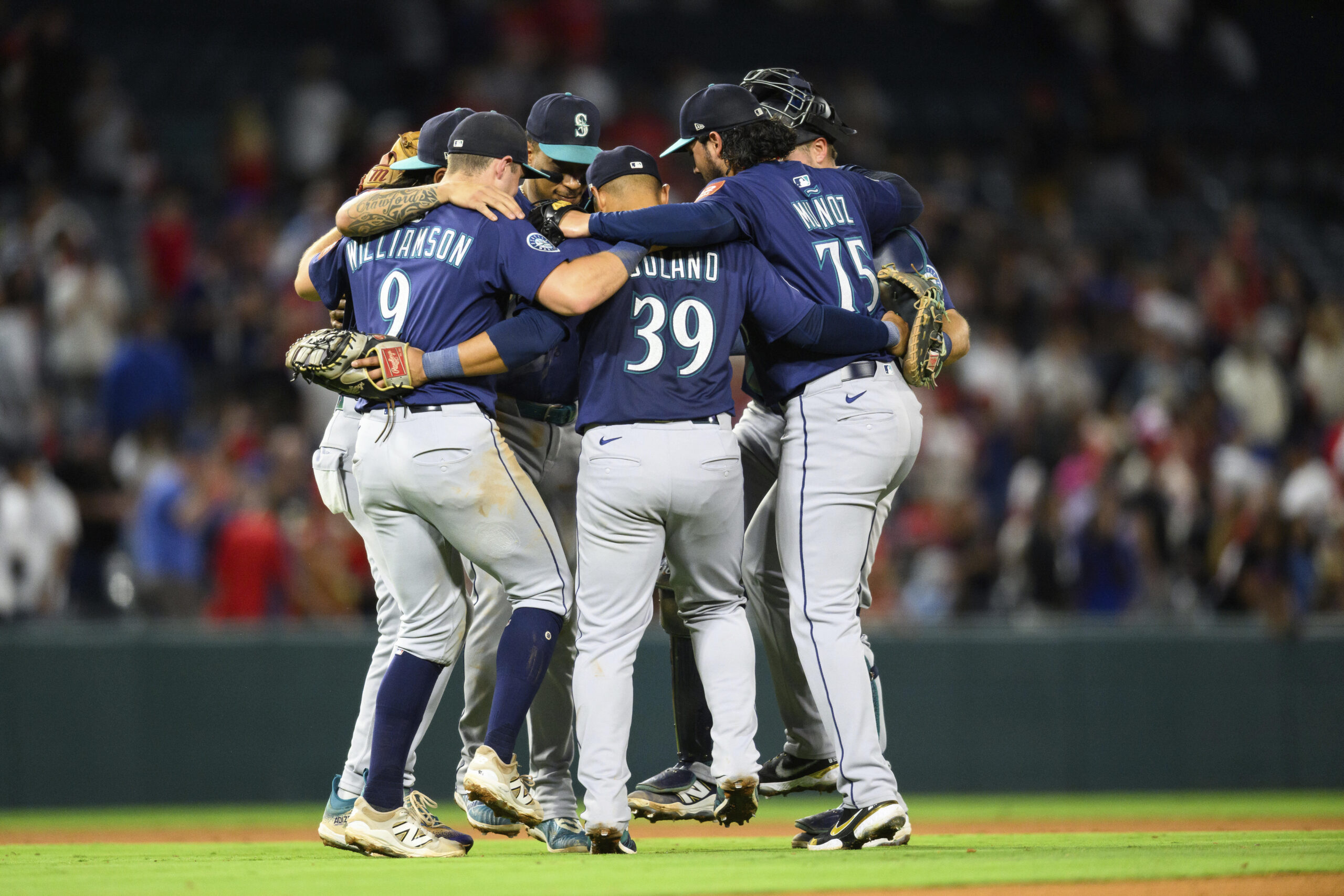 Seattle Mariners players celebrate after winning a baseball game against...