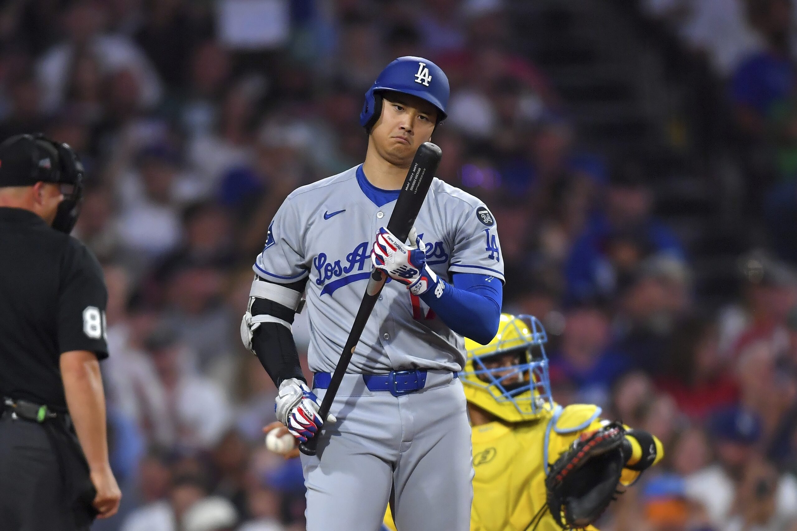 Dodgers’ Shohei Ohtani examines his bat before striking out in...