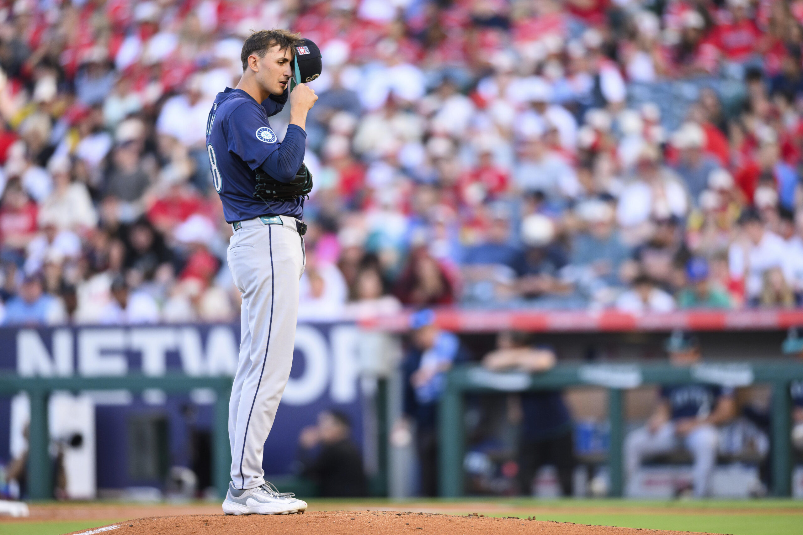 Seattle Mariners pitcher George Kirby tries to hear a call...