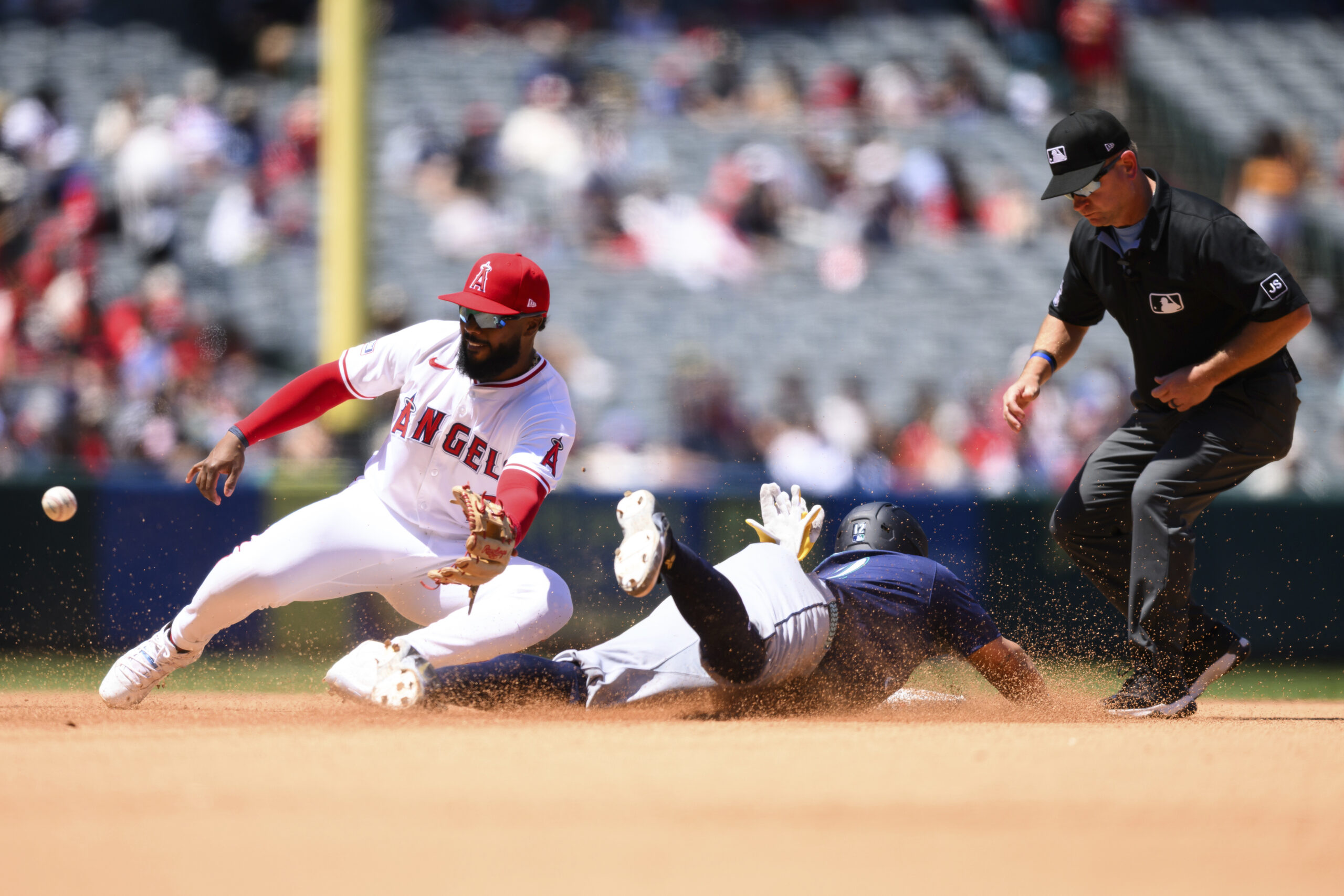Seattle Mariners’ Josh Naylor, right, safely steals second as Angels...
