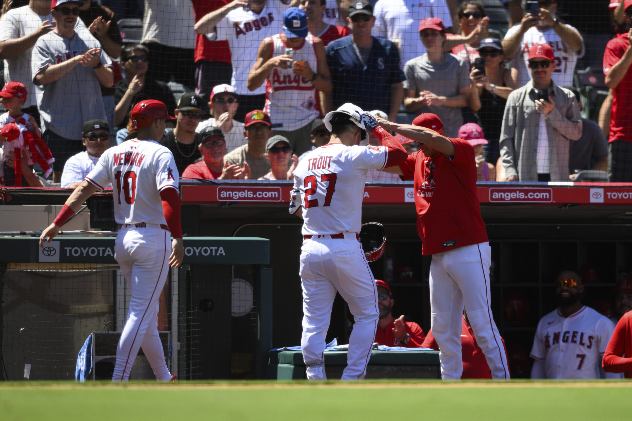 Angels’ Mike Trout, center, is greeted by teammates after hitting...