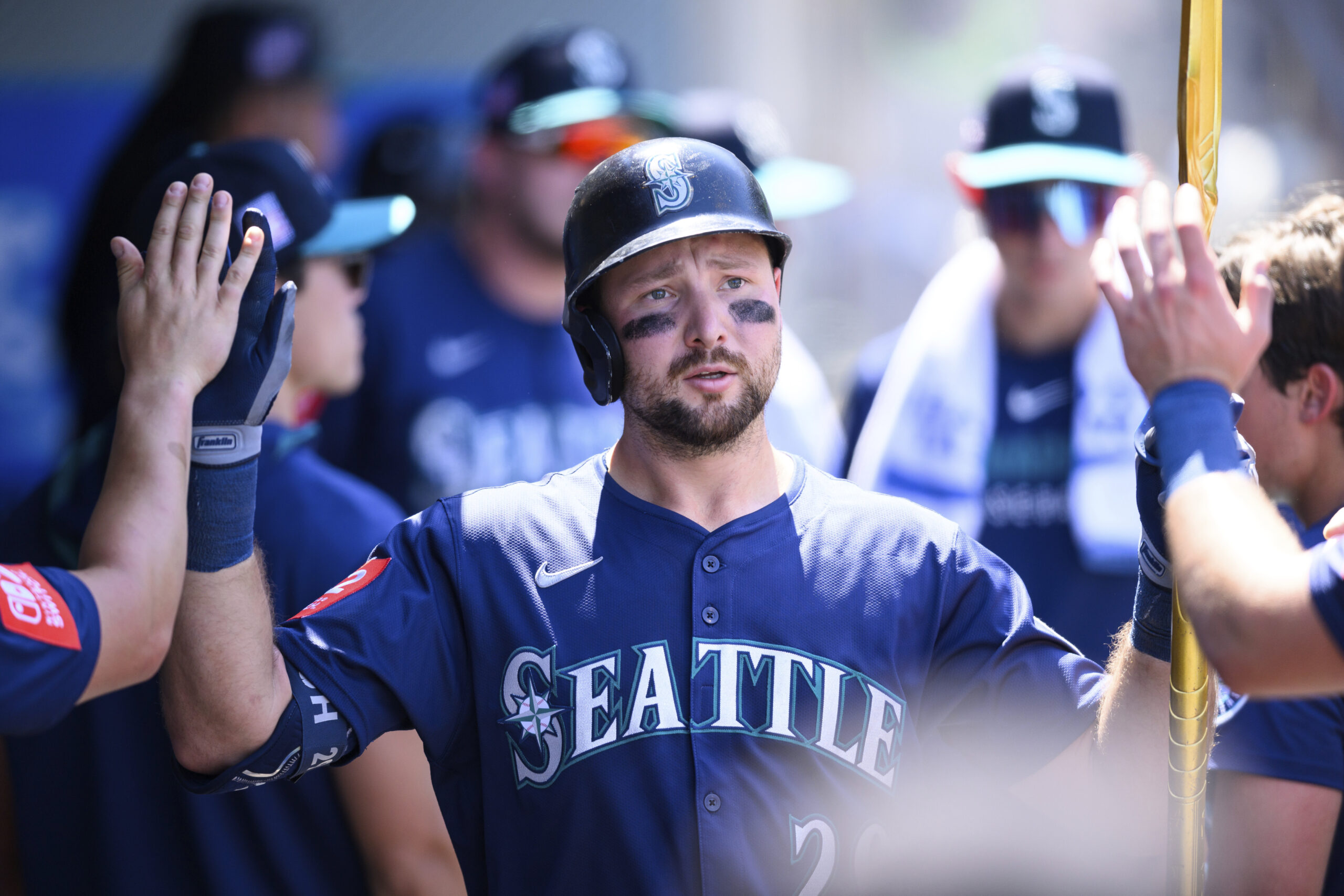 Seattle Mariners’ Cal Raleigh is greeted by teammates after hitting...