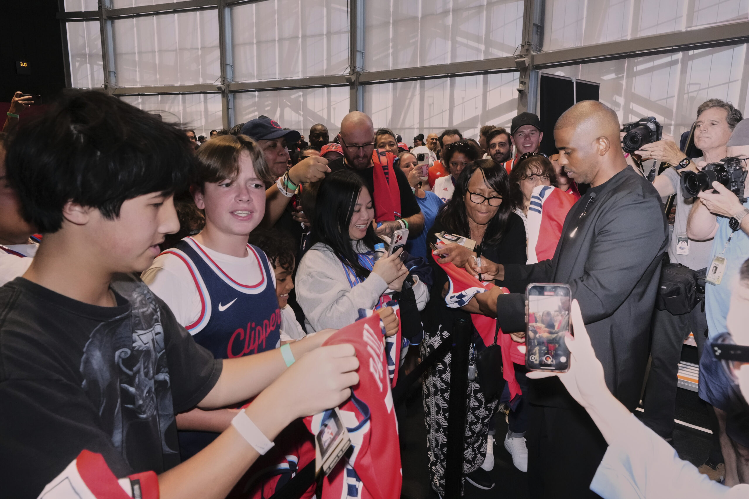 Clippers guard Chris Paul signs autographs for fans after a...
