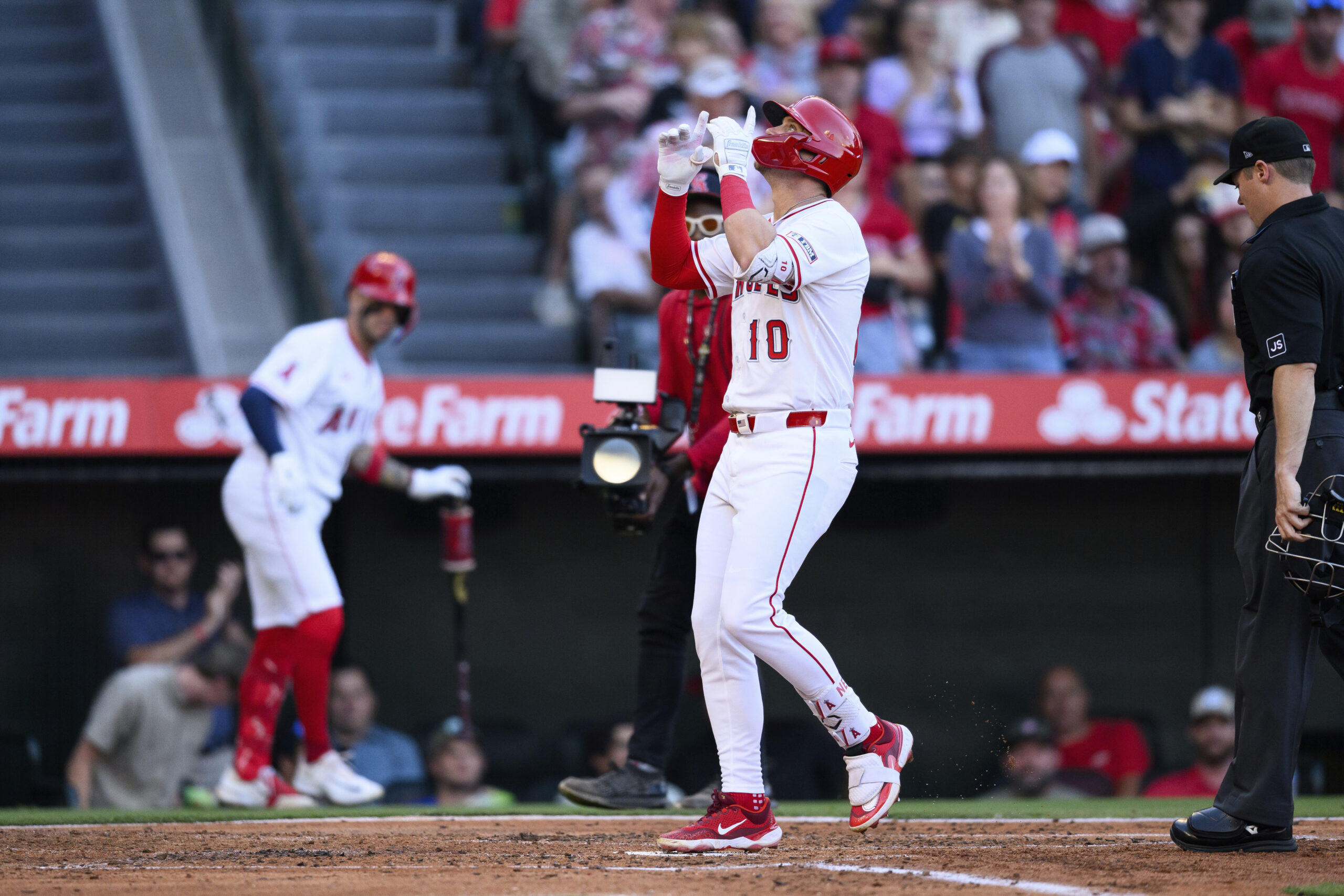 The Angels’ Kevin Newman gestures after running the bases following...
