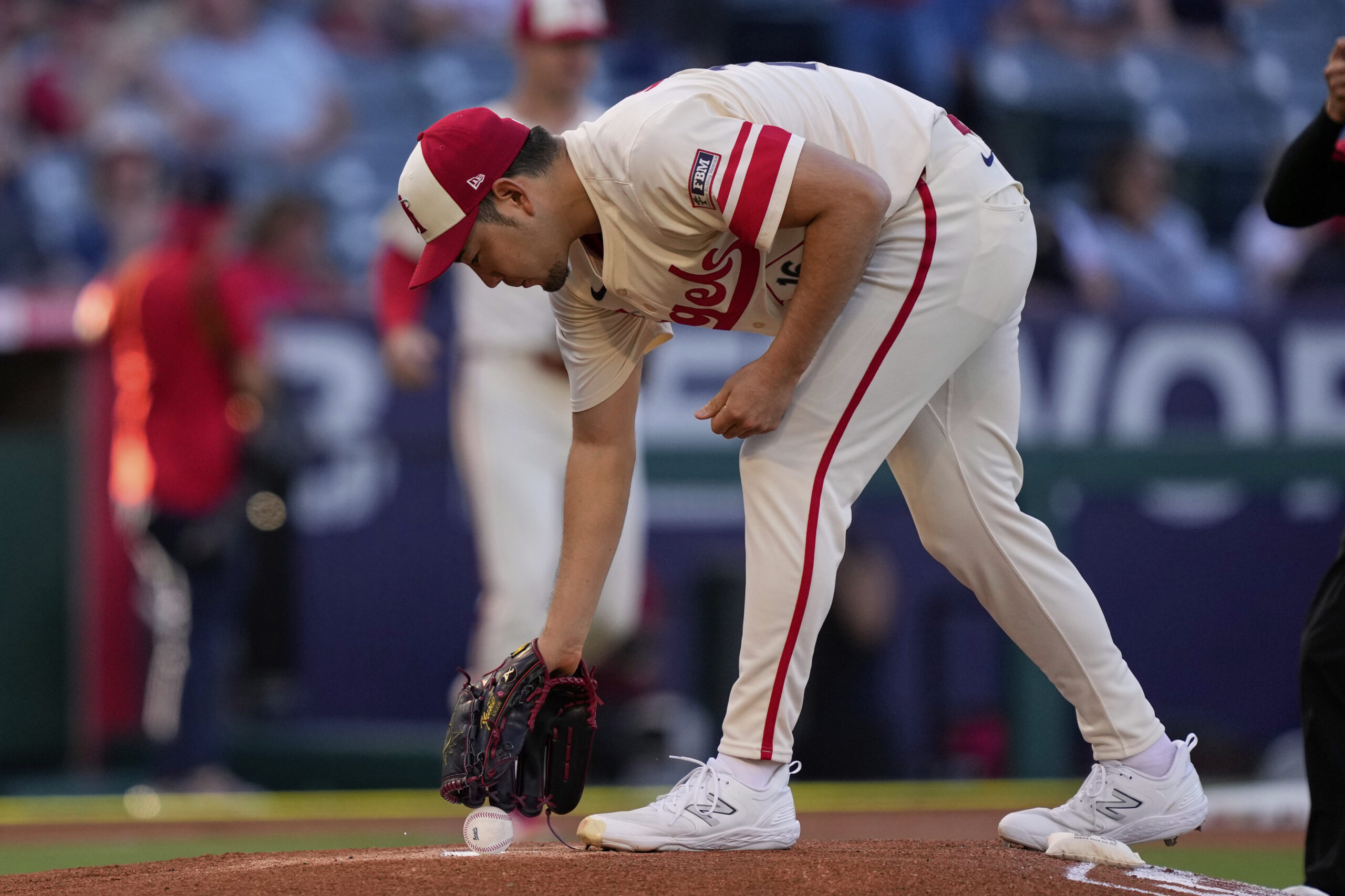 Angels starting pitcher Yusei Kikuchi picks up a baseball before...