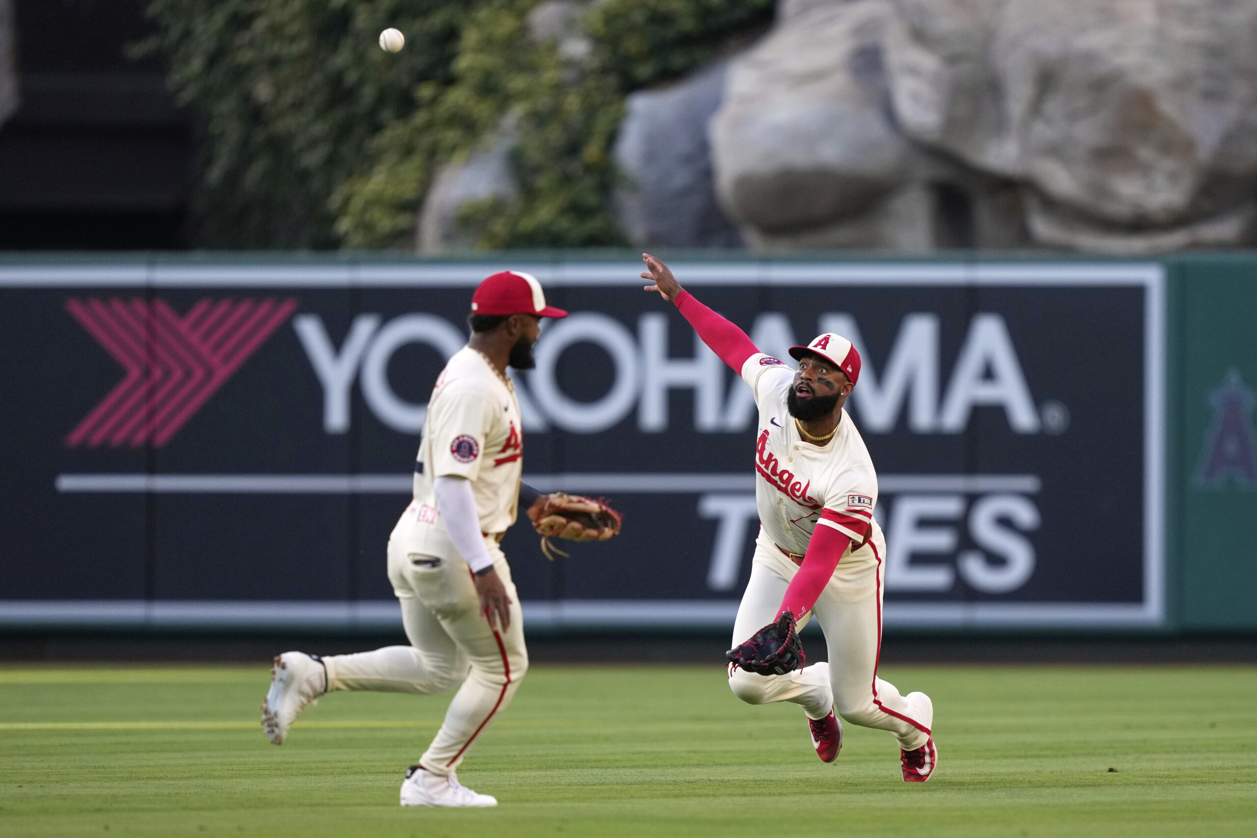 Angels center fielder Jo Adell, right, is unable to handle...