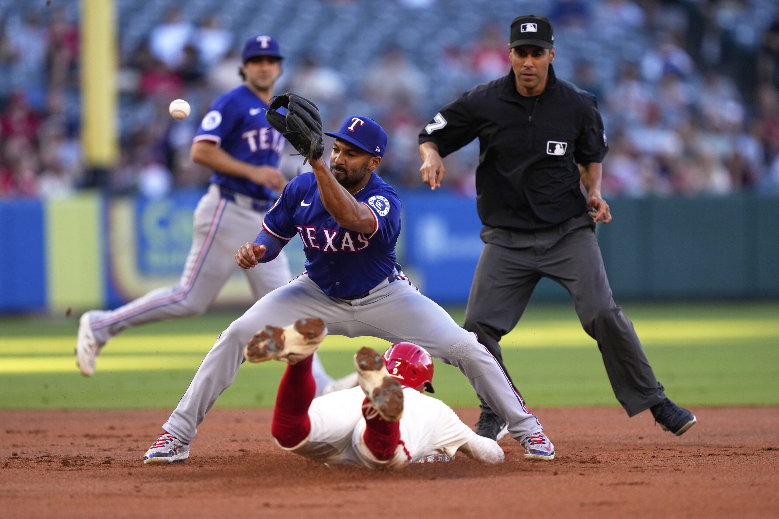 The Angels’ Zach Neto, below, steals second base as Texas...
