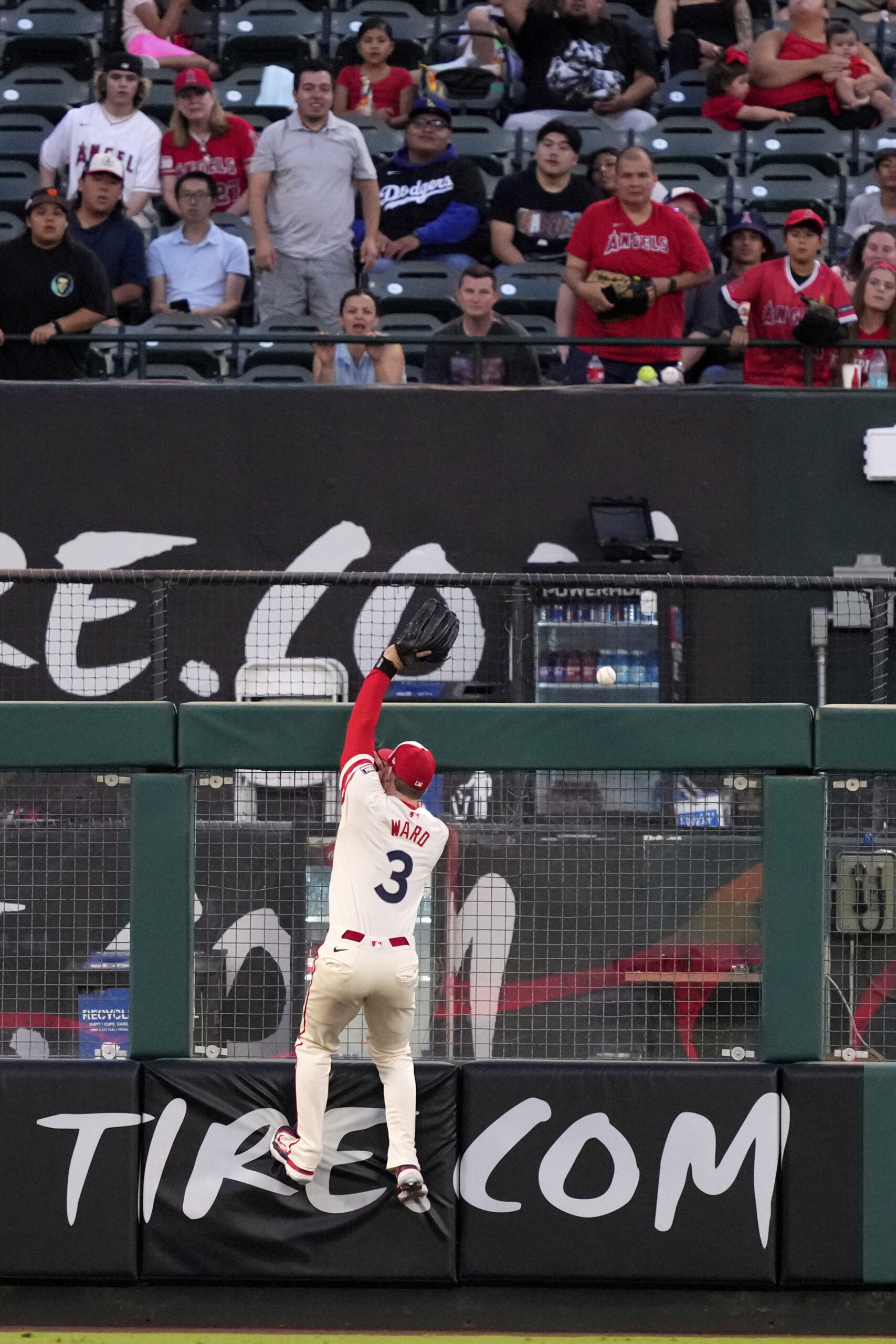 Angels left fielder Taylor Ward can’t get to a ball...