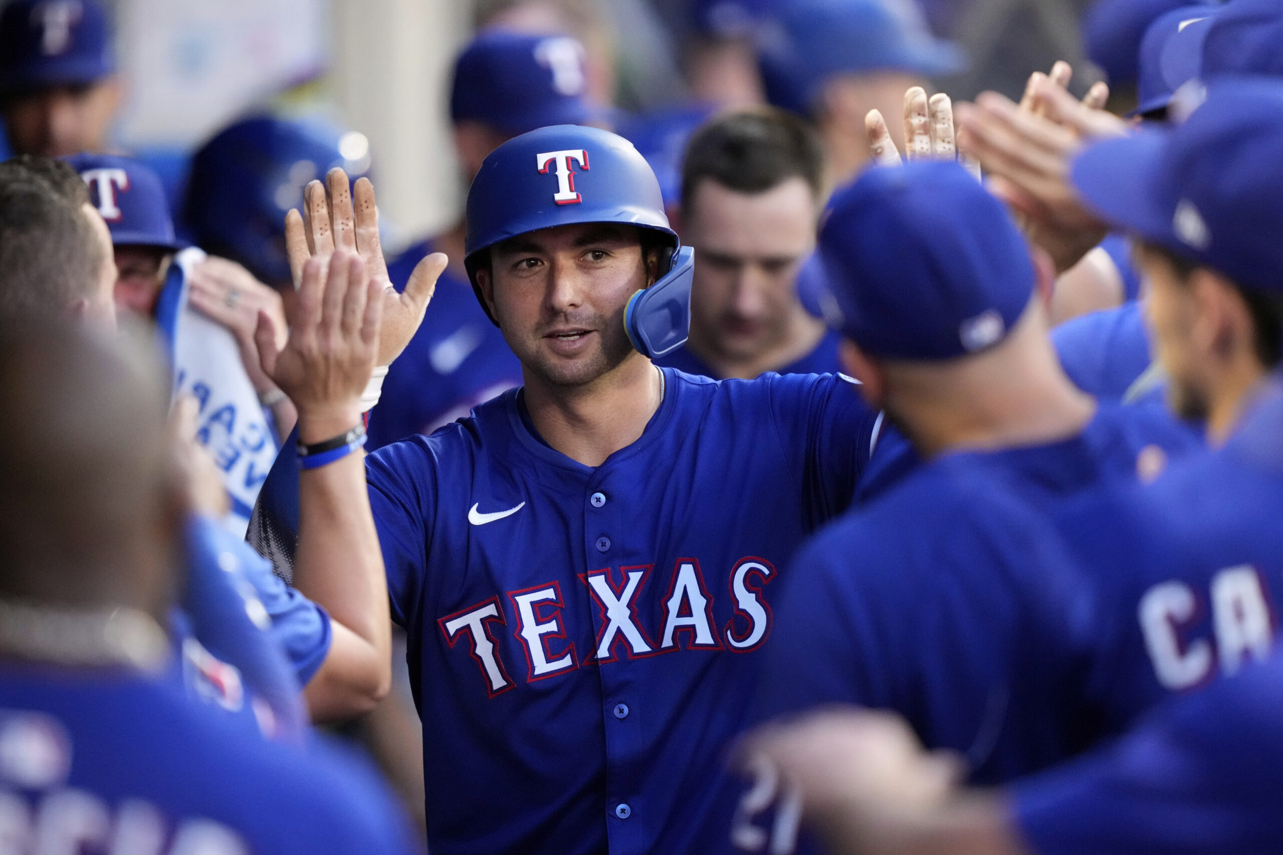 The Texas Rangers’ Kyle Higashioka is congratulated by teammates in...