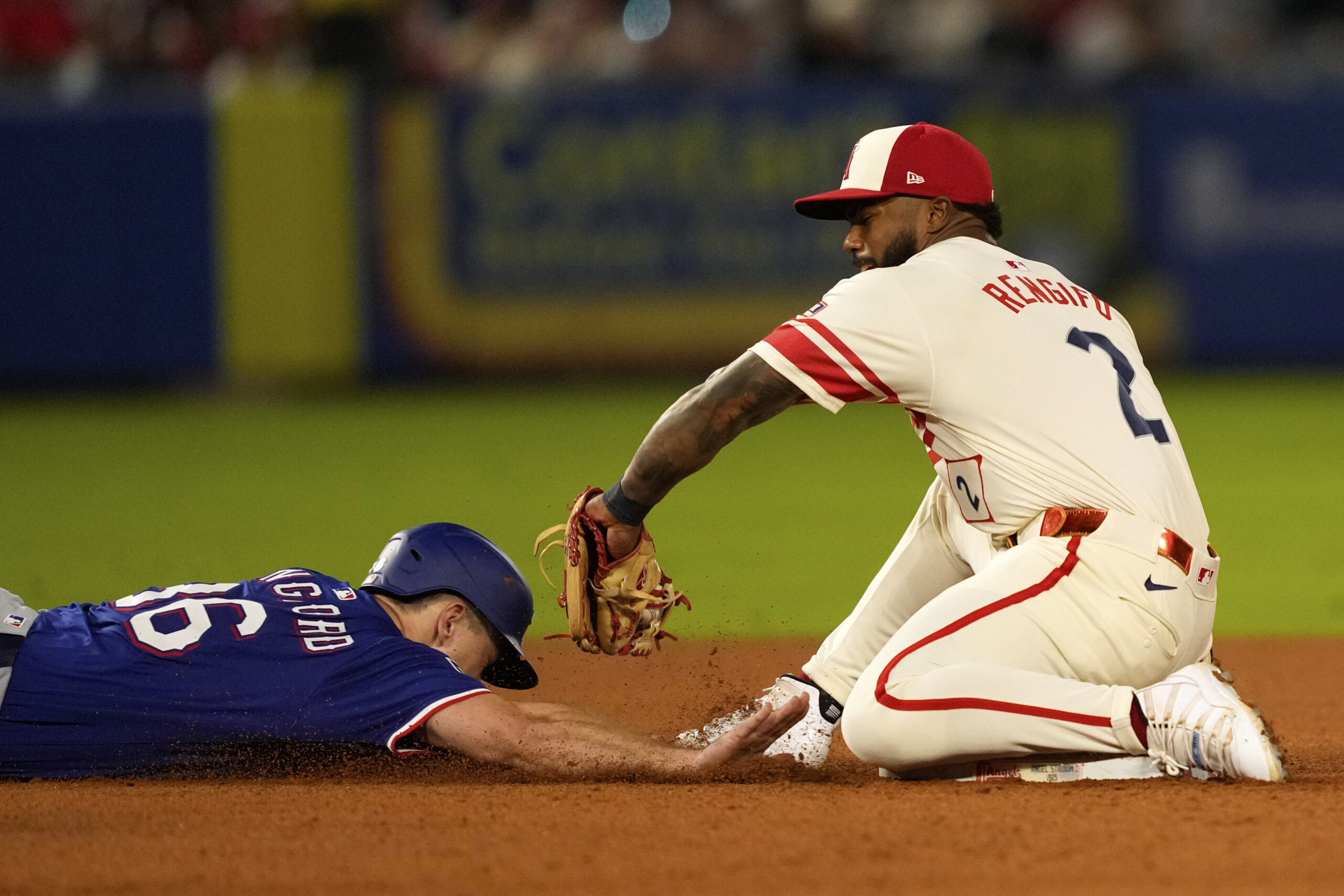 The Texas Rangers’ Wyatt Langford, left, is tagged out at...