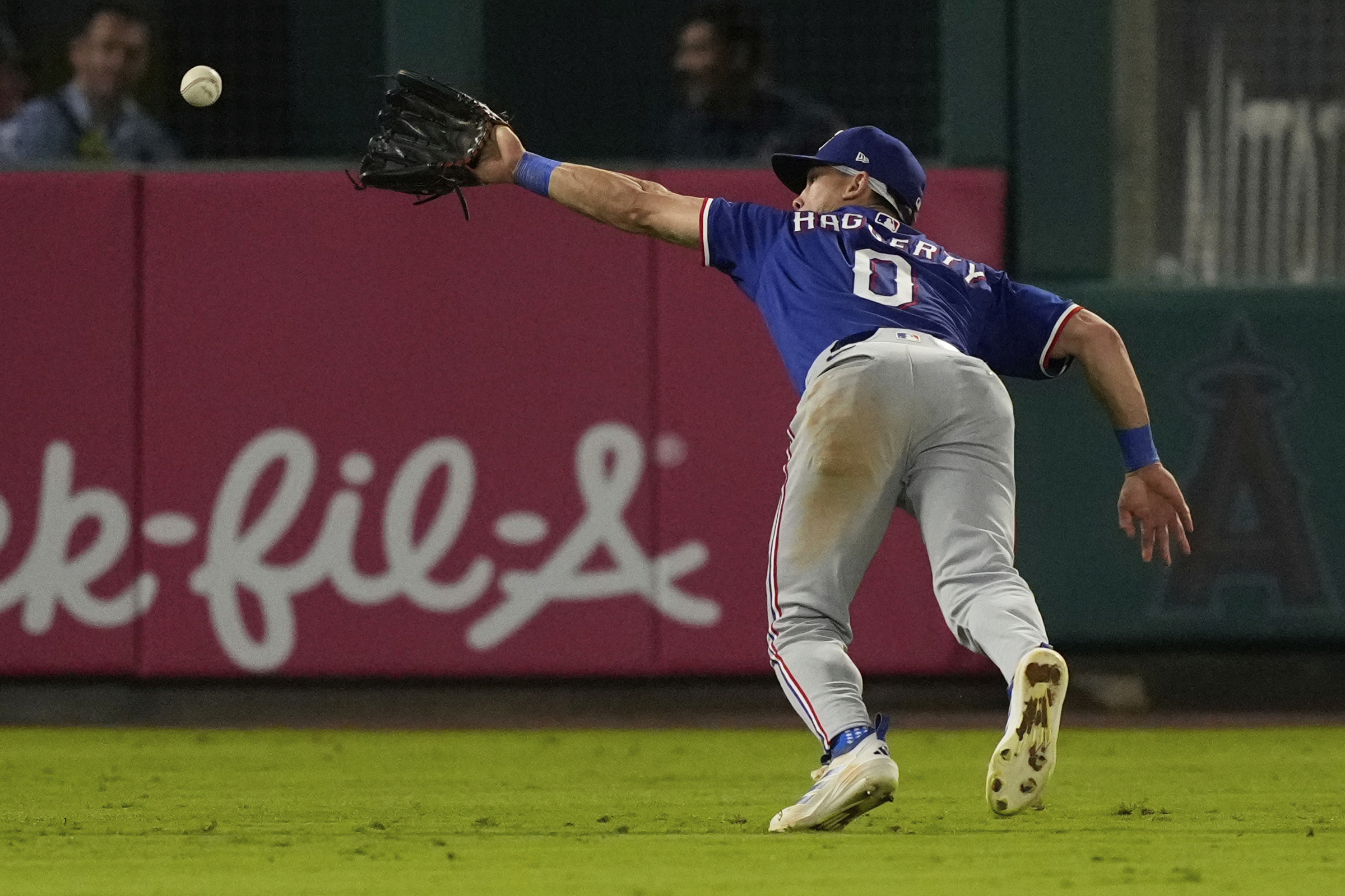 Texas Rangers left fielder Sam Haggerty can’t handle a ball...