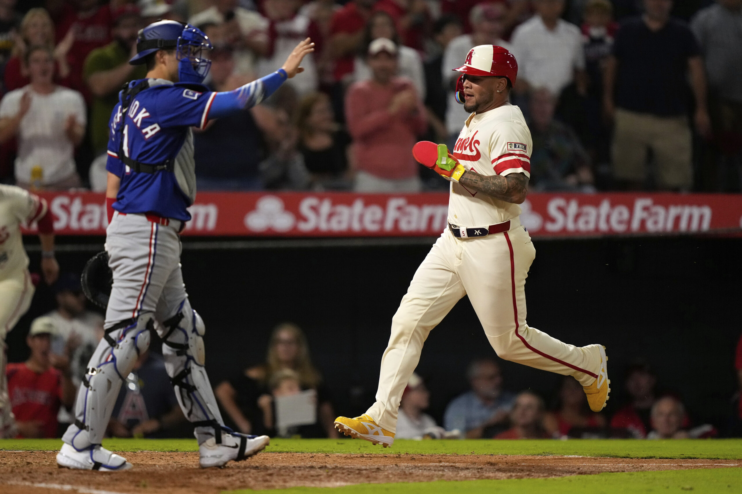 The Angels’ Yoan Moncada, right, scores on a double by...
