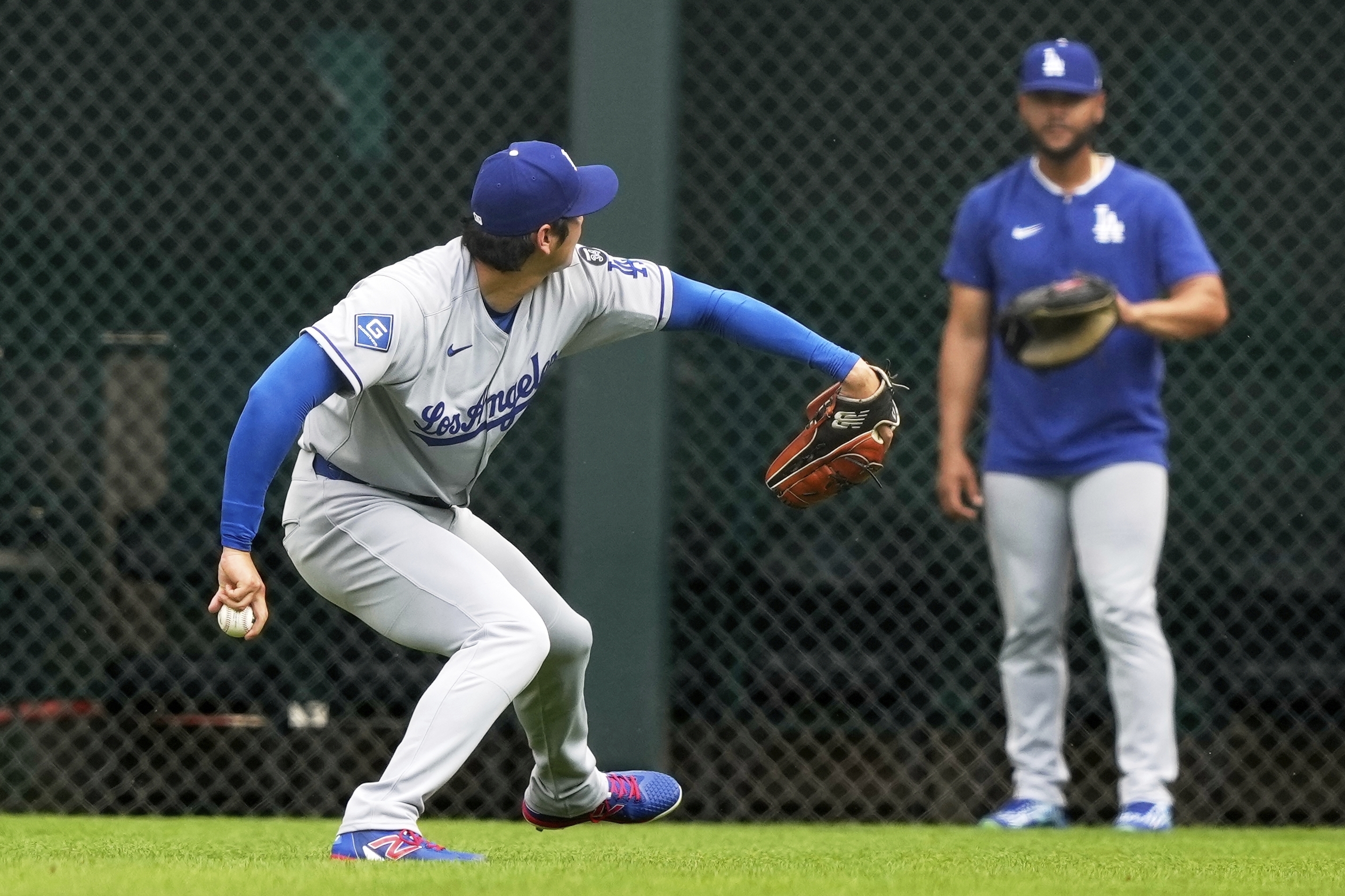 Dodgers starting pitcher Shohei Ohtani warms up before a baseball...