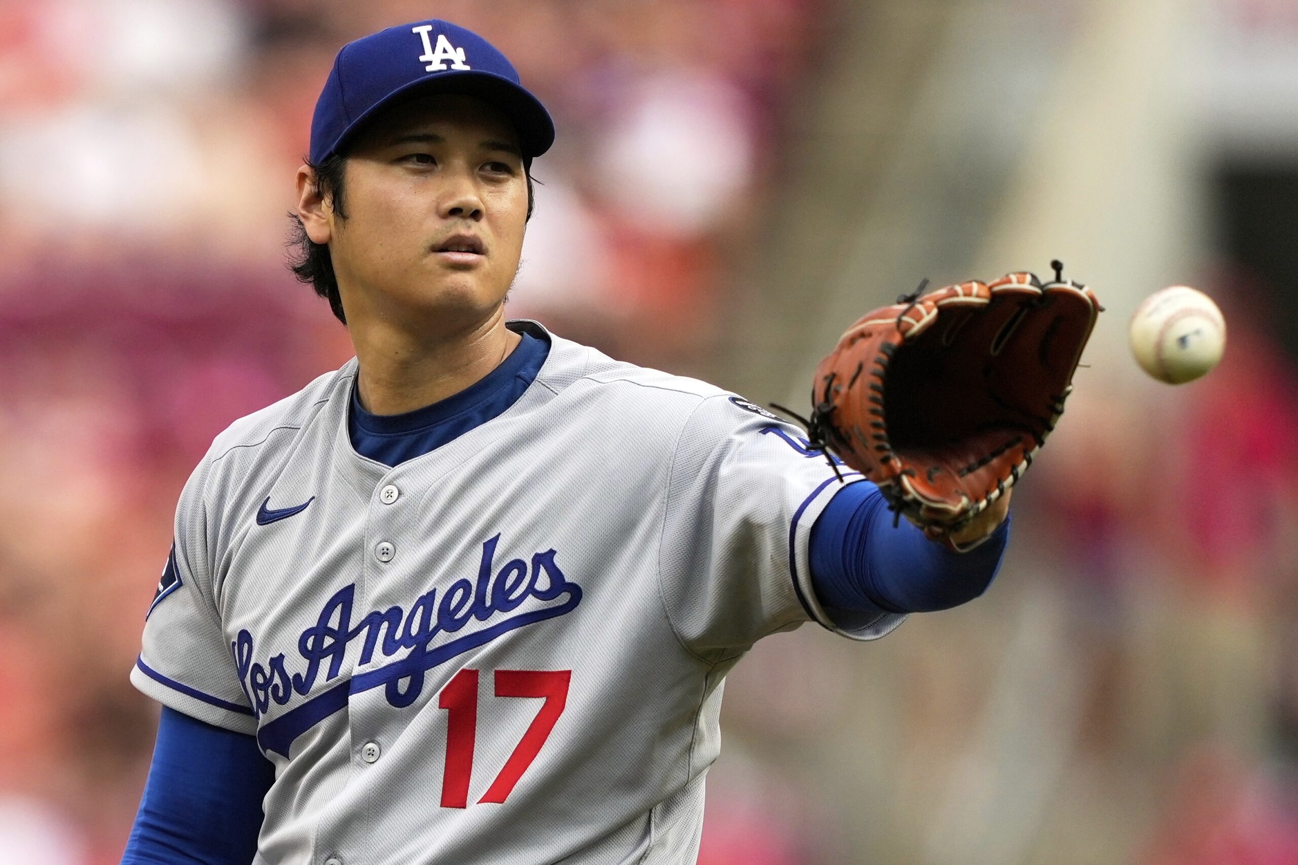 Dodgers starting pitcher Shohei Ohtani takes the throw from his...