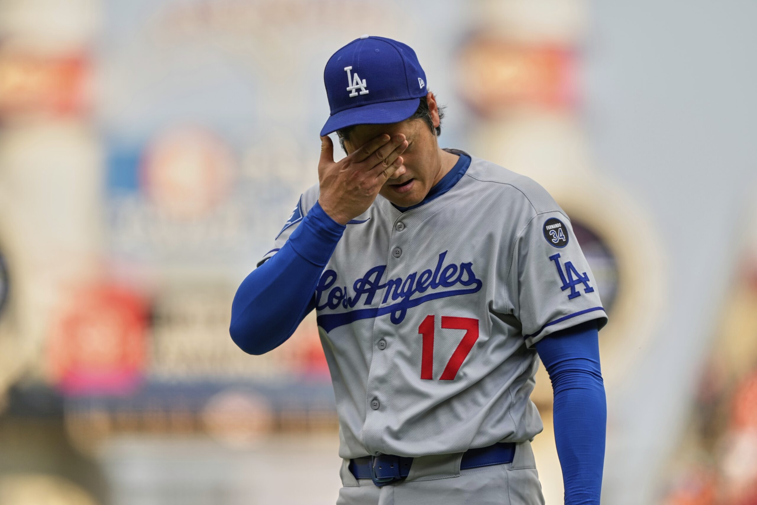 Dodgers starting pitcher Shohei Ohtani reacts after throwing during the...