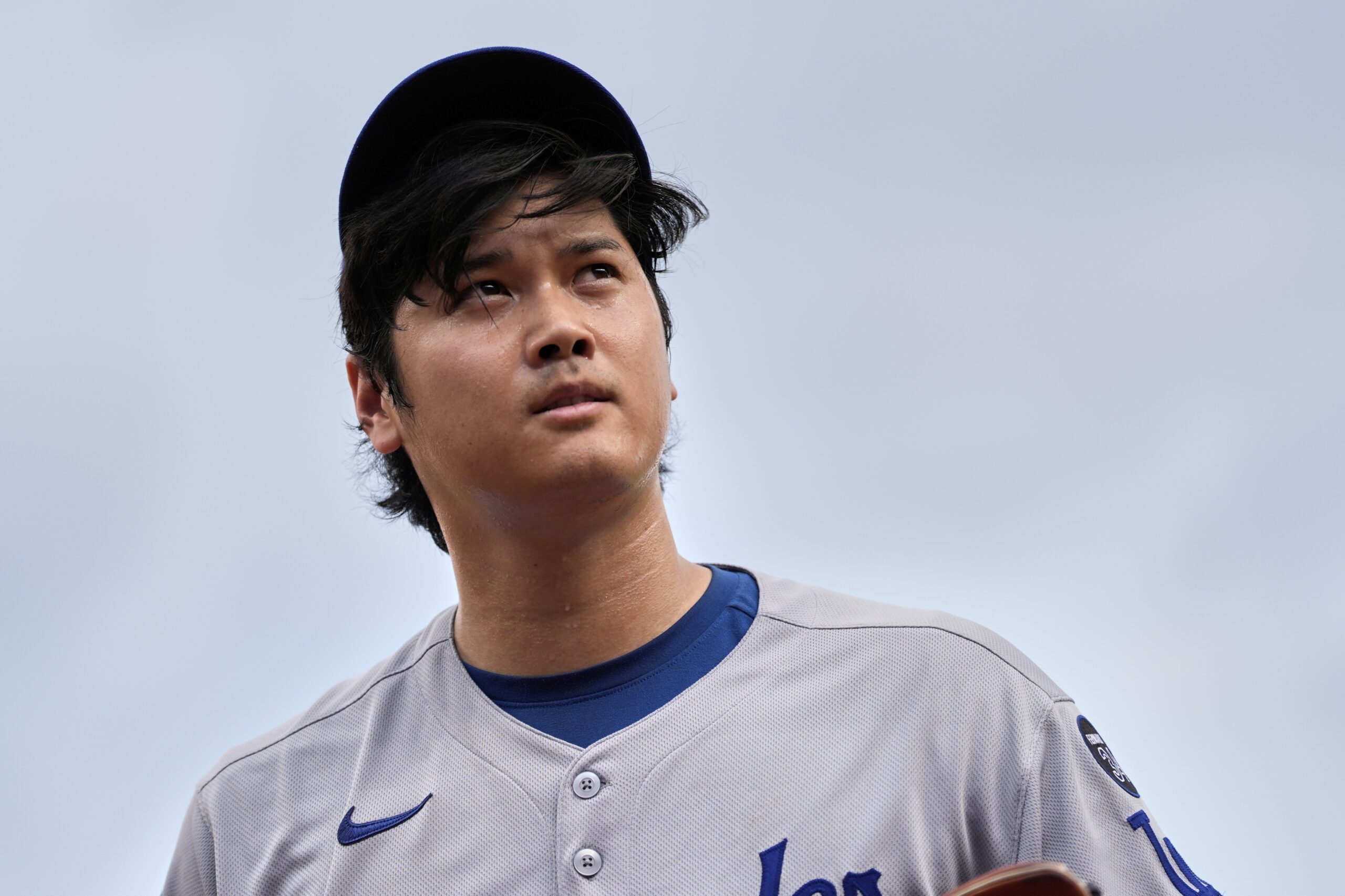 Dodgers starting pitcher Shohei Ohtani reacts after throwing during the...