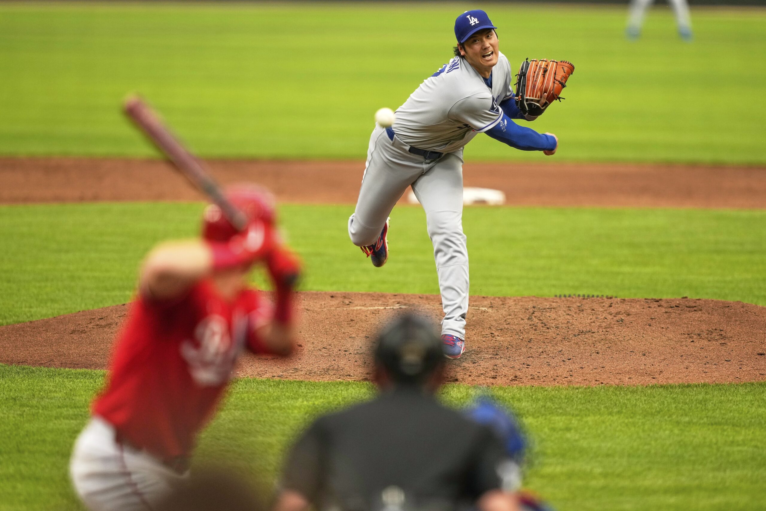 Dodgers starting pitcher Shohei Ohtani throws to the plate during...