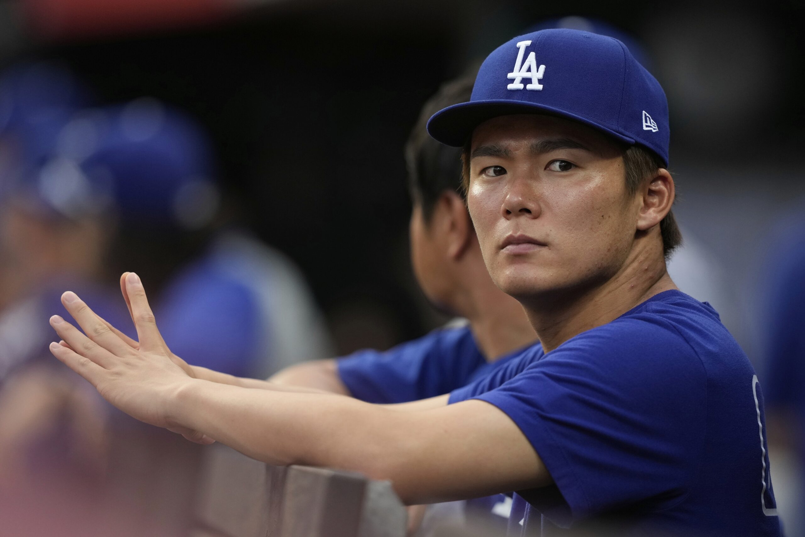 Dodgers pitcher Yoshinobu Yamamoto watches from the dugout during the...