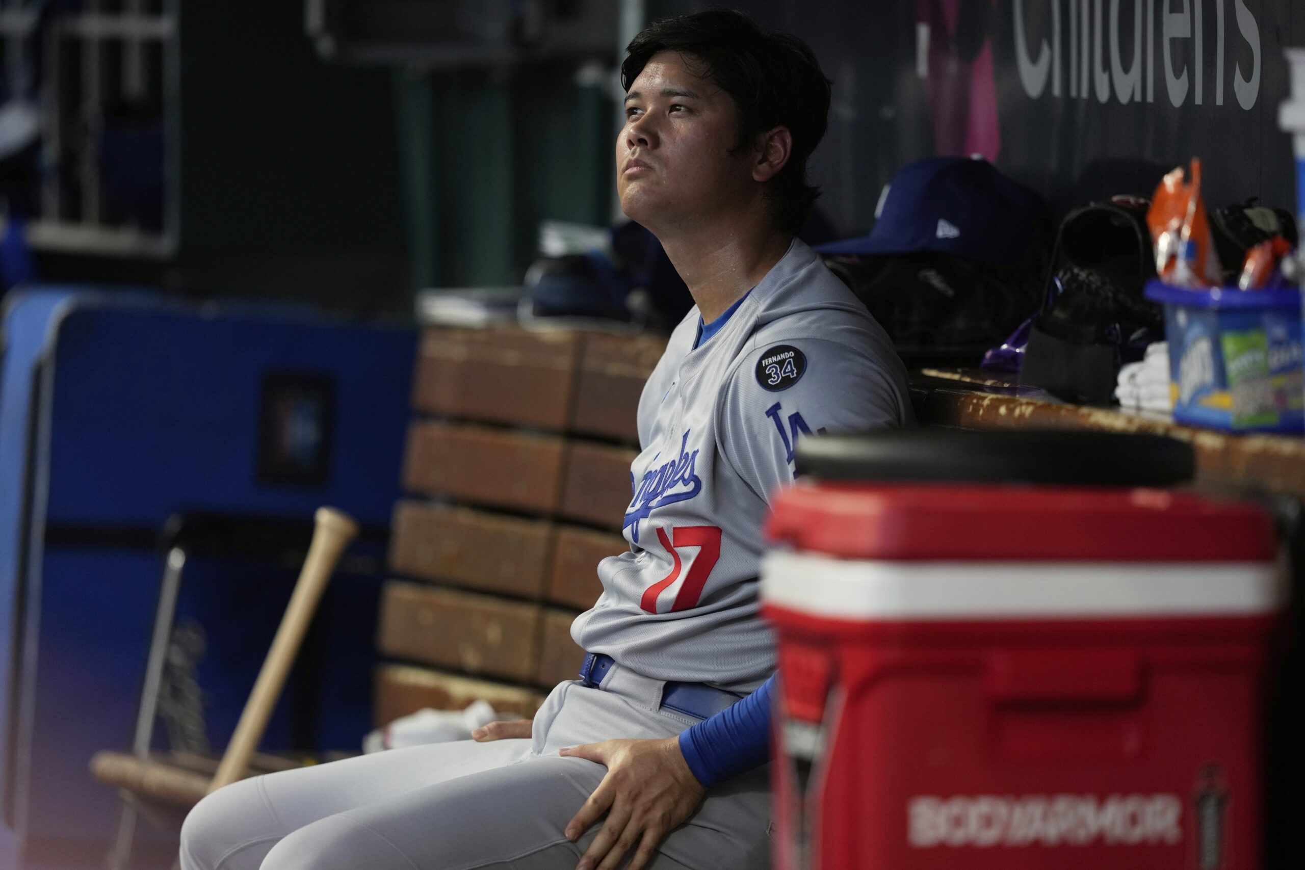 Dodgers star Shohei Ohtani sits in the dugout during the...