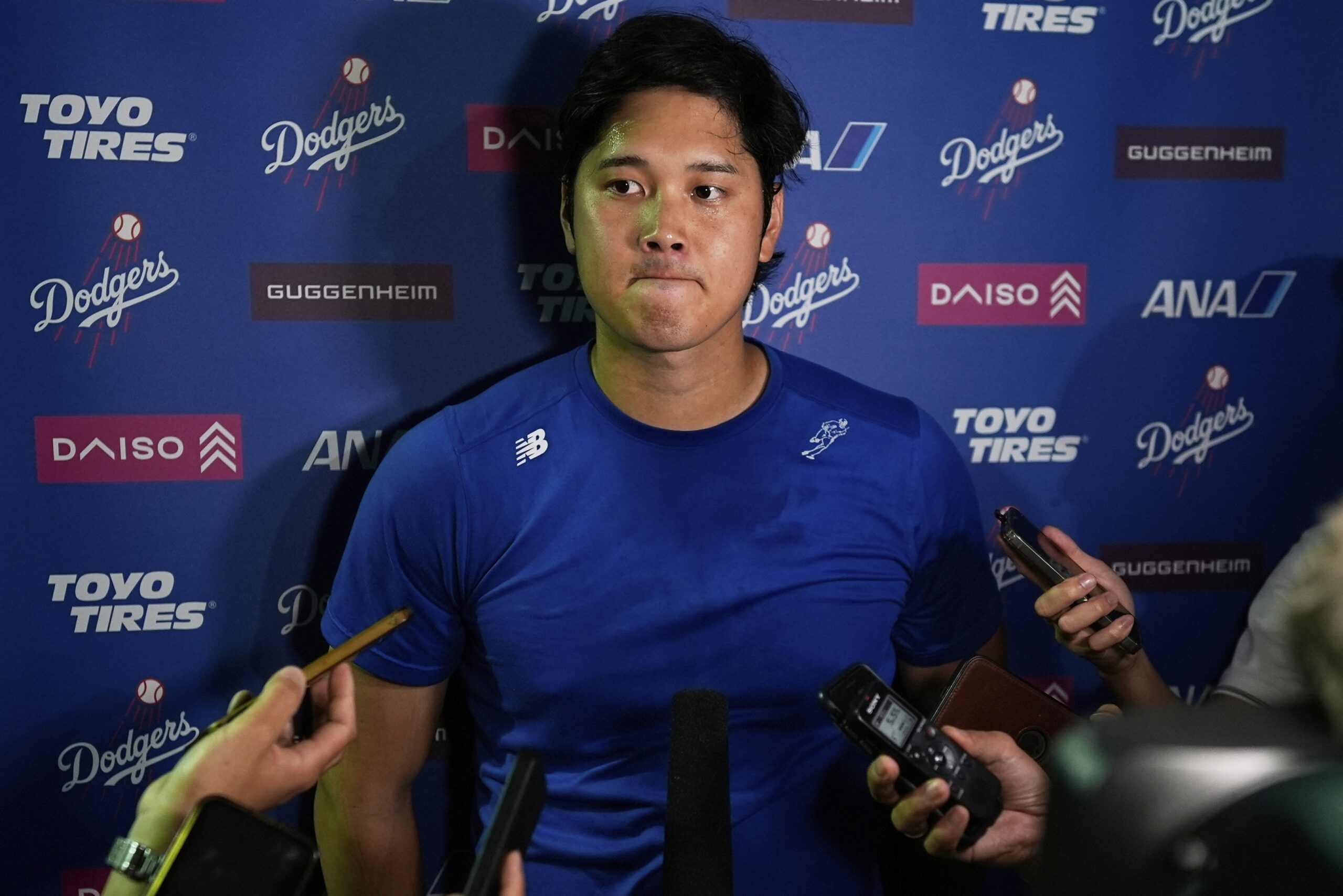 Dodgers star Shohei Ohtani talks to reporters after a game...
