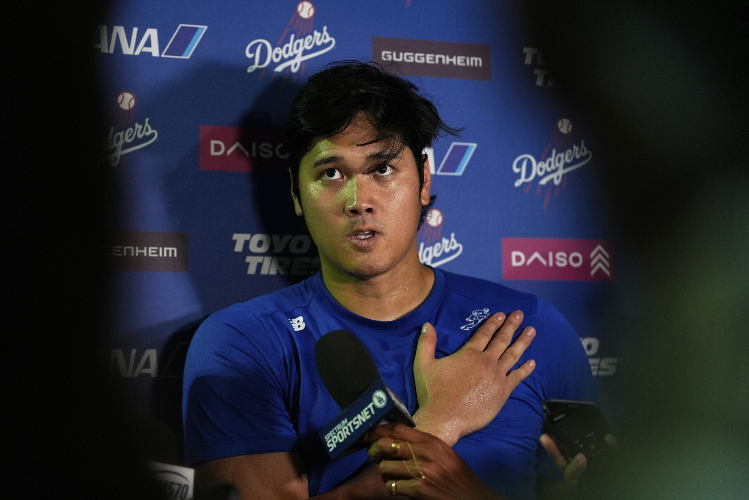 Dodgers star Shohei Ohtani talks to reporters after a game...